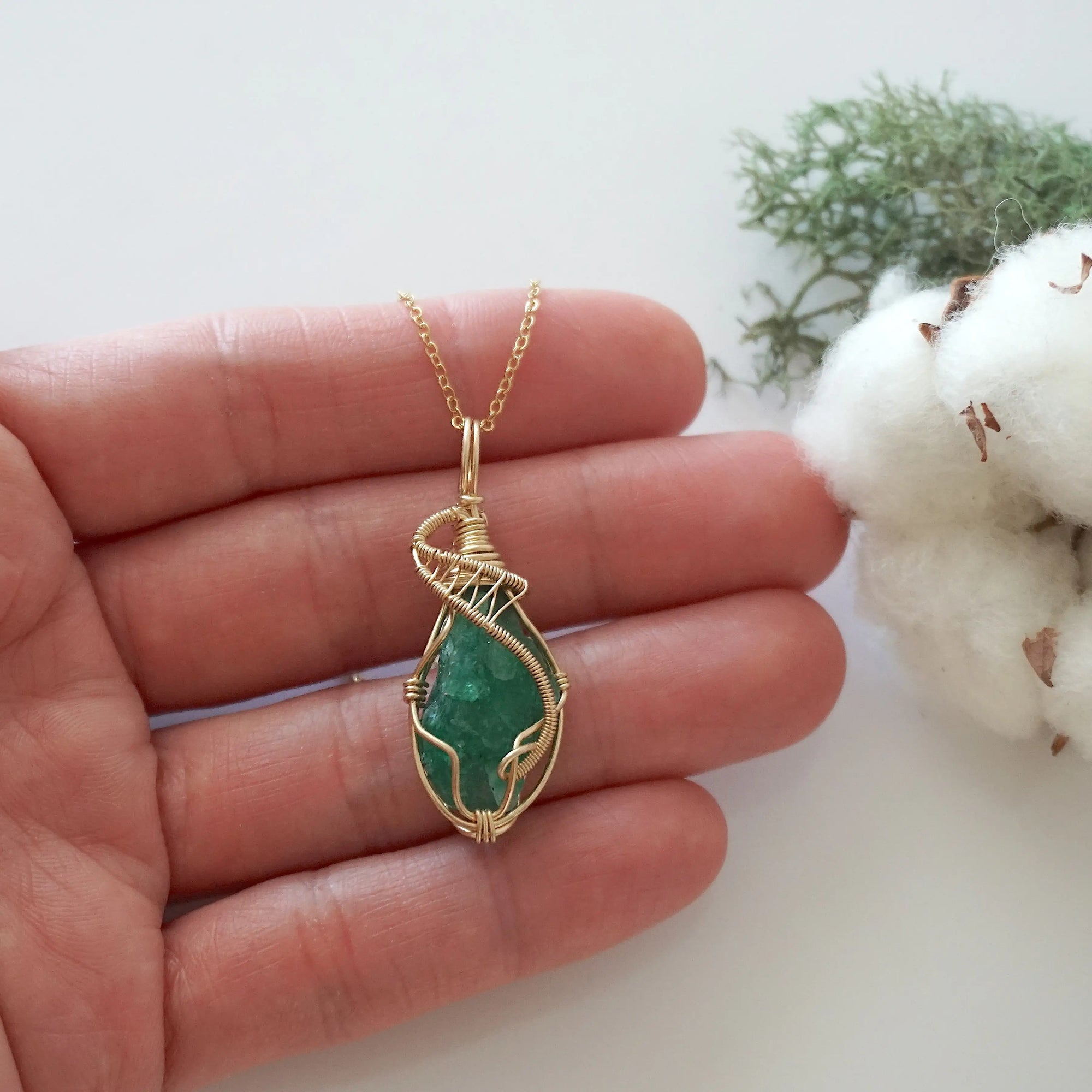 Raw emerald necklace in 14k gold filled shown in hand for size reference. Artisan May birthstone pendant by Designs by Nature Gems.