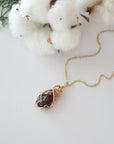 Raw garnet necklace in 14k gold filled laying flat. Handcrafted January birthstone jewelry for women by Designs by Nature Gems.