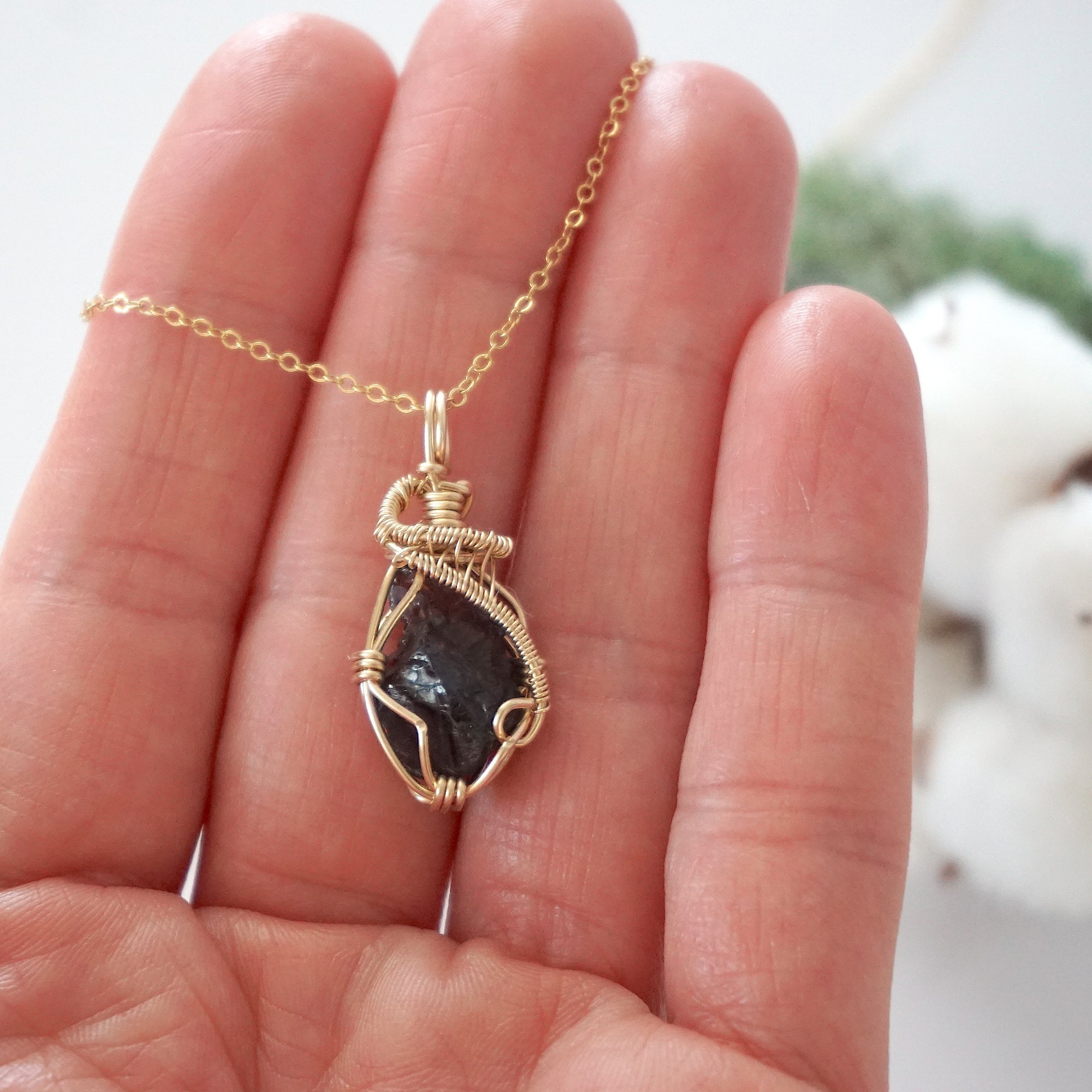 Raw garnet necklace in 14k gold filled shown in hand for size reference. Artisan January birthstone pendant by Designs by Nature Gems.