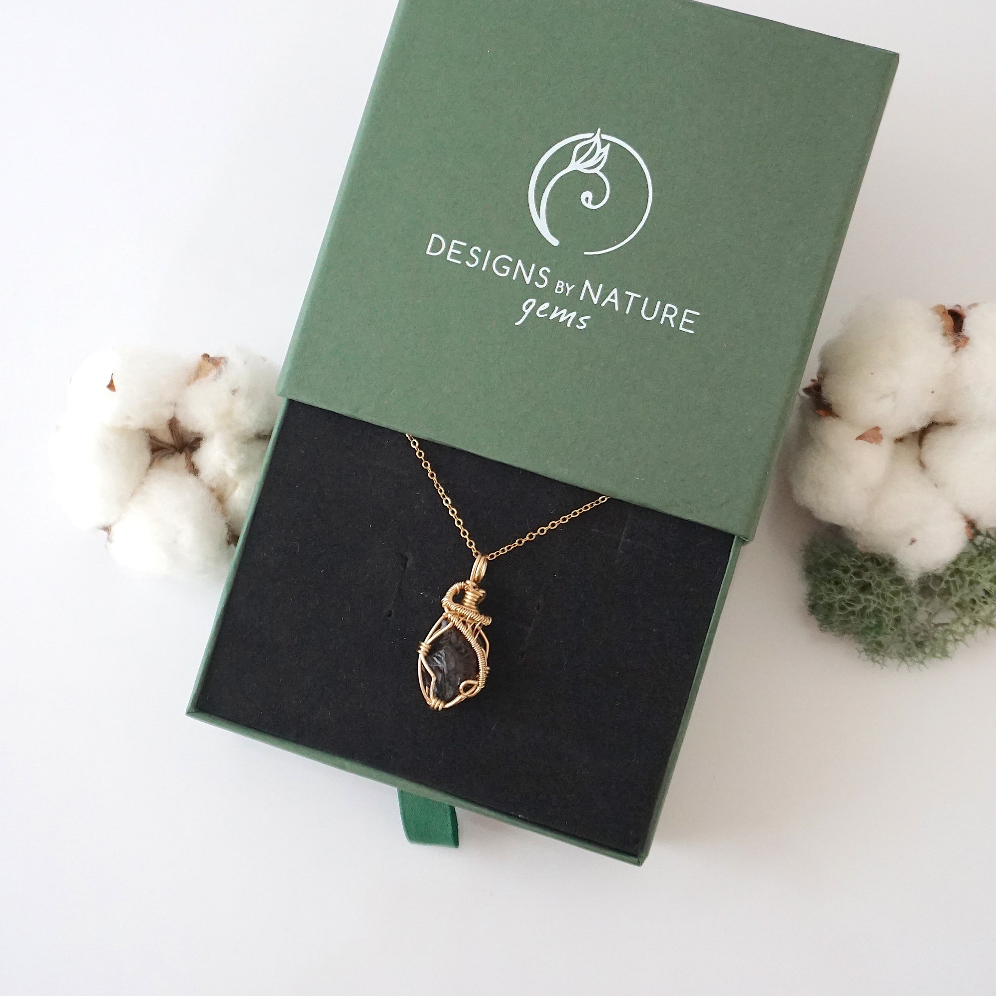 Raw garnet necklace in 14k gold filled displayed in branded Designs by Nature Gems jewelry box. Artisan January birthstone gift for women.