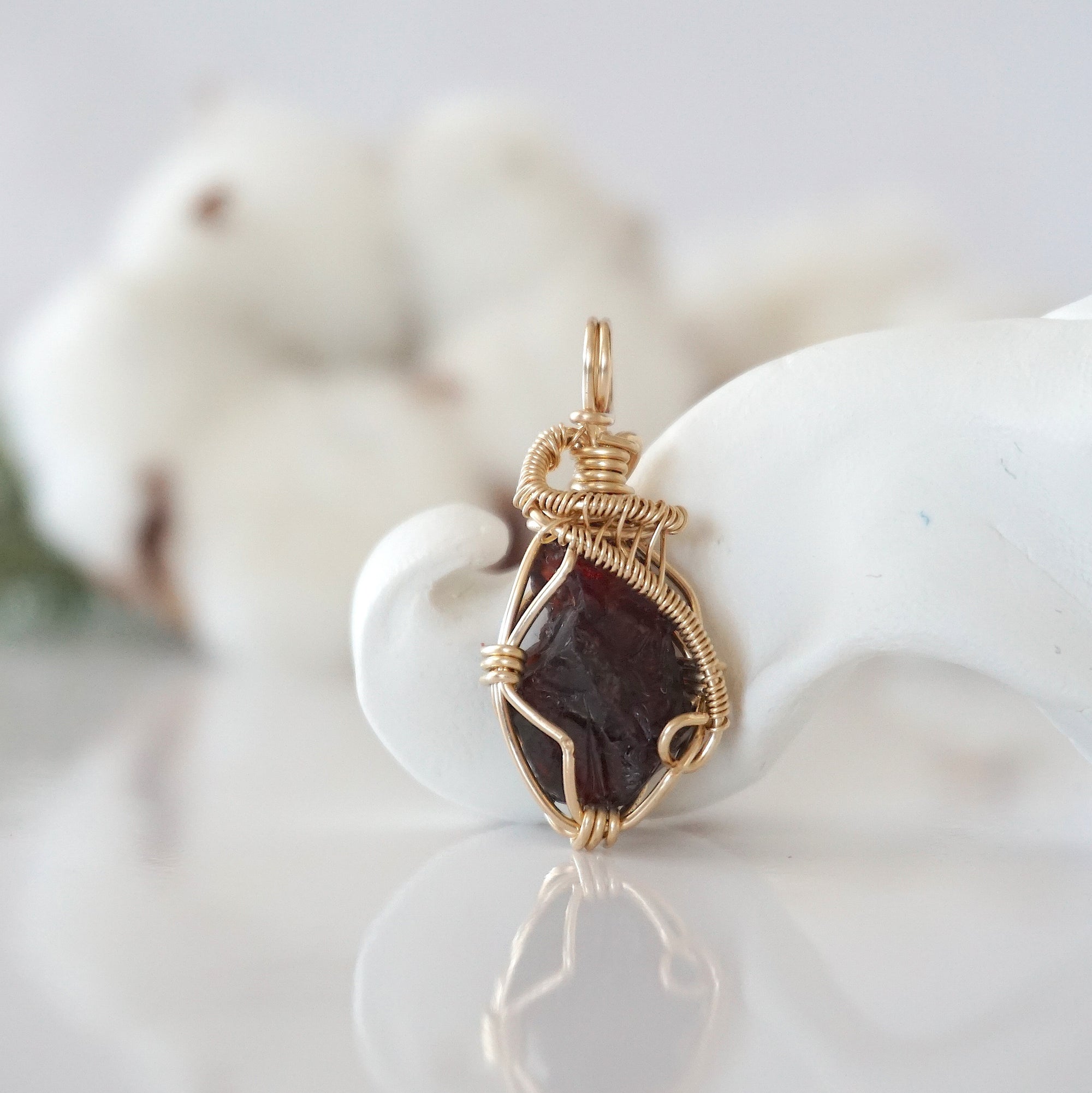 Detailed front view of raw garnet pendant in 14k gold filled. Unique wire wrapped January birthstone jewelry by Designs by Nature Gems.