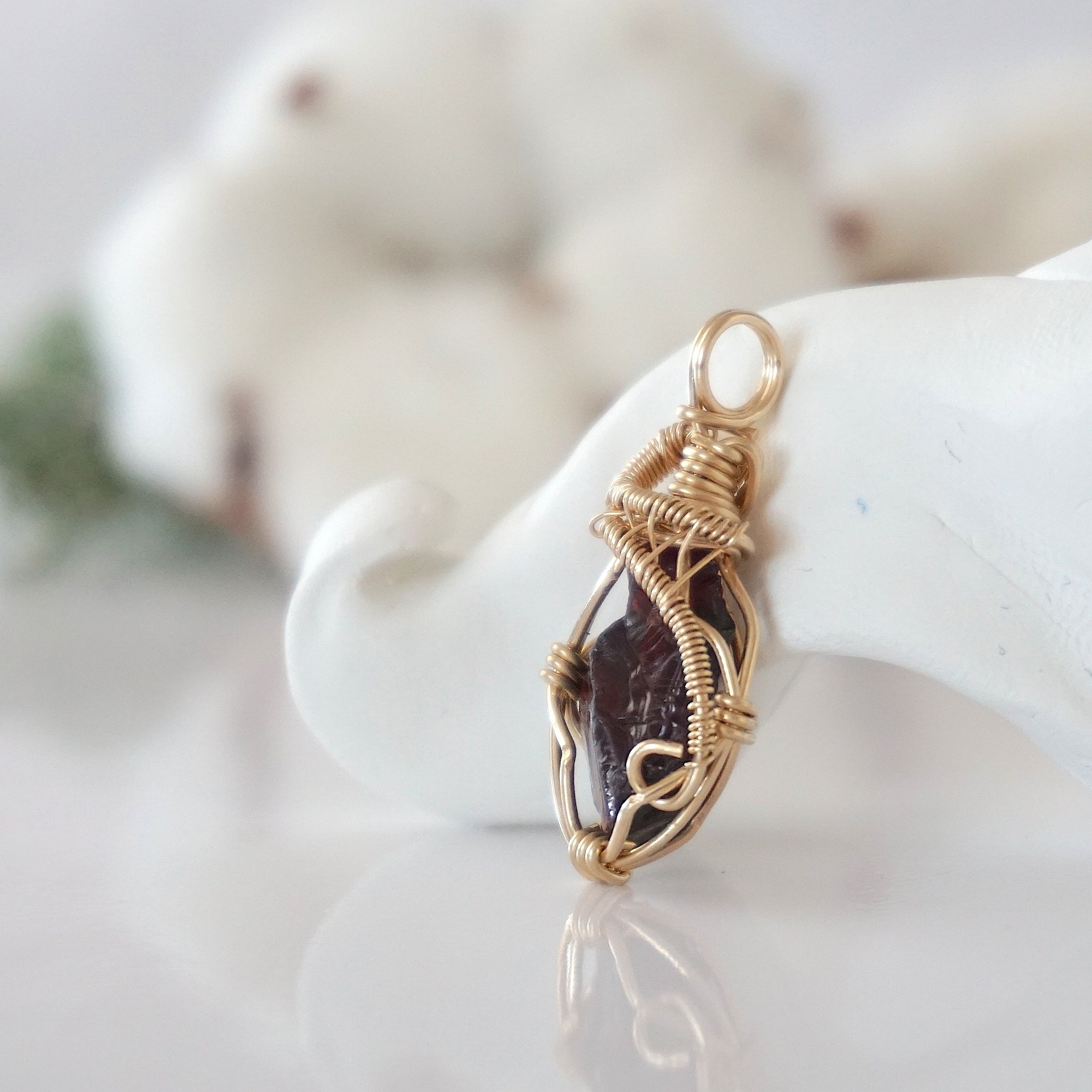 Side view of raw garnet pendant in 14k gold filled, showing artisan wire wrapping. Handcrafted January birthstone necklace by Designs by Nature Gems.