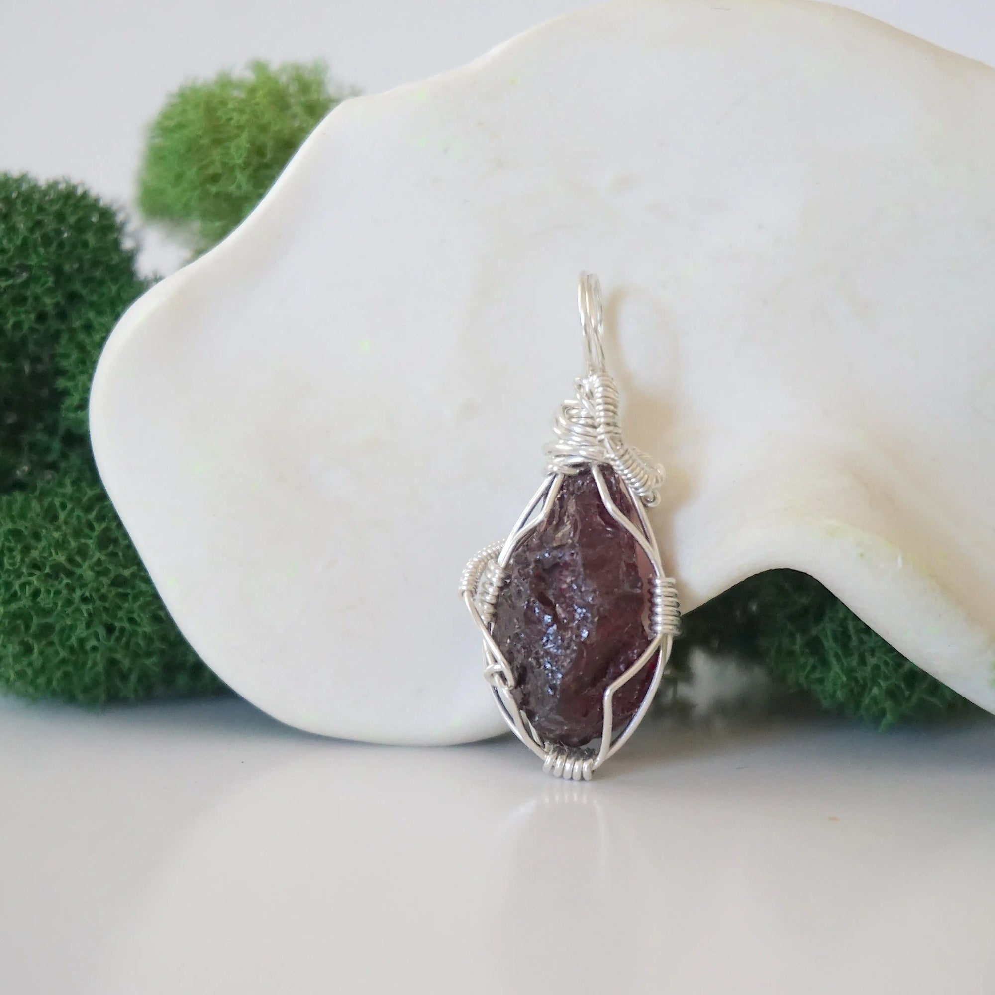 Back view of raw garnet necklace pendant with handcrafted sterling silver wire work