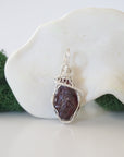Close up front view of raw garnet crystal with detailed 925 sterling silver wire wrapping