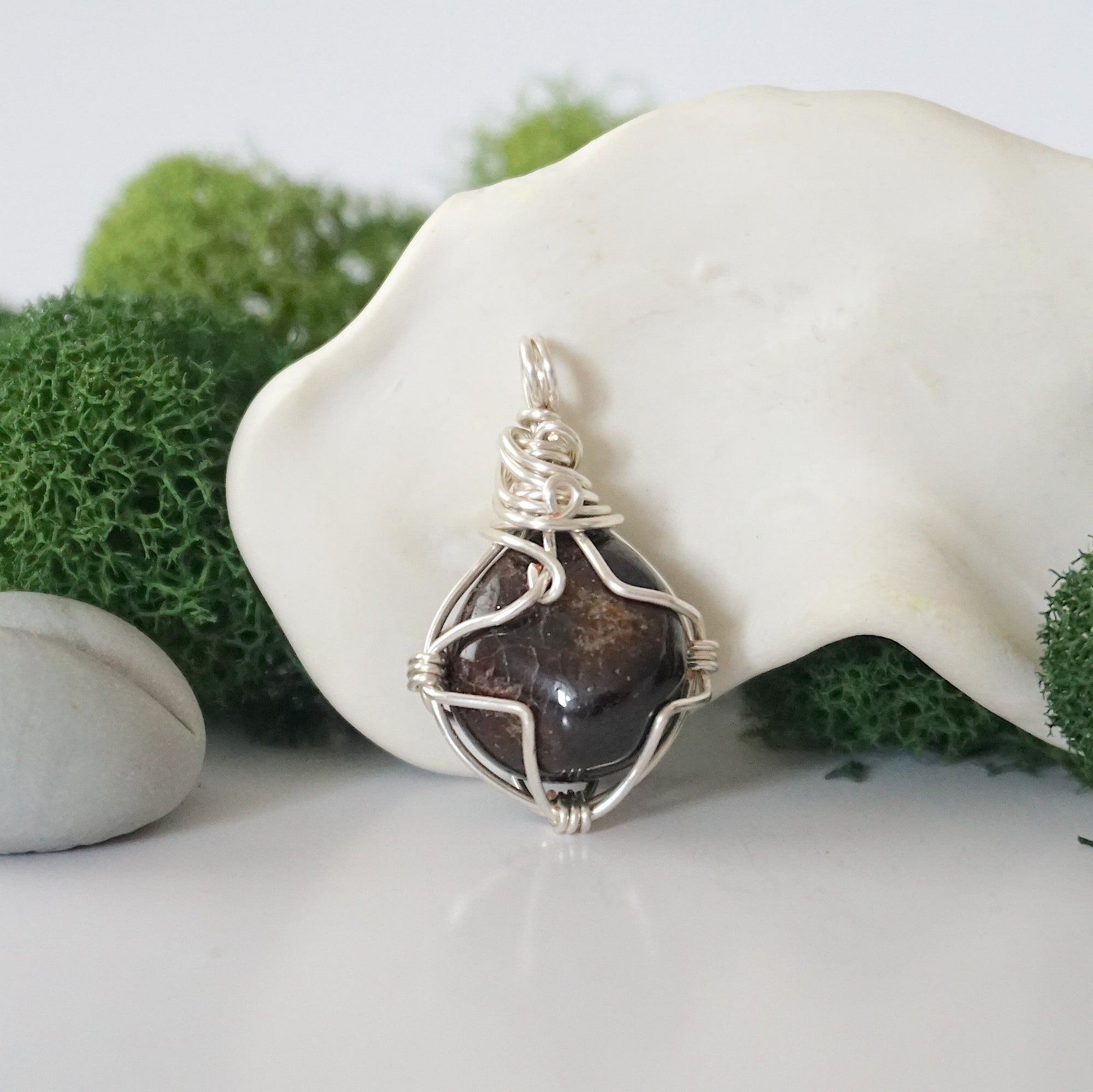 Back angle look at simple raw garnet pendant with silver wire wrapping