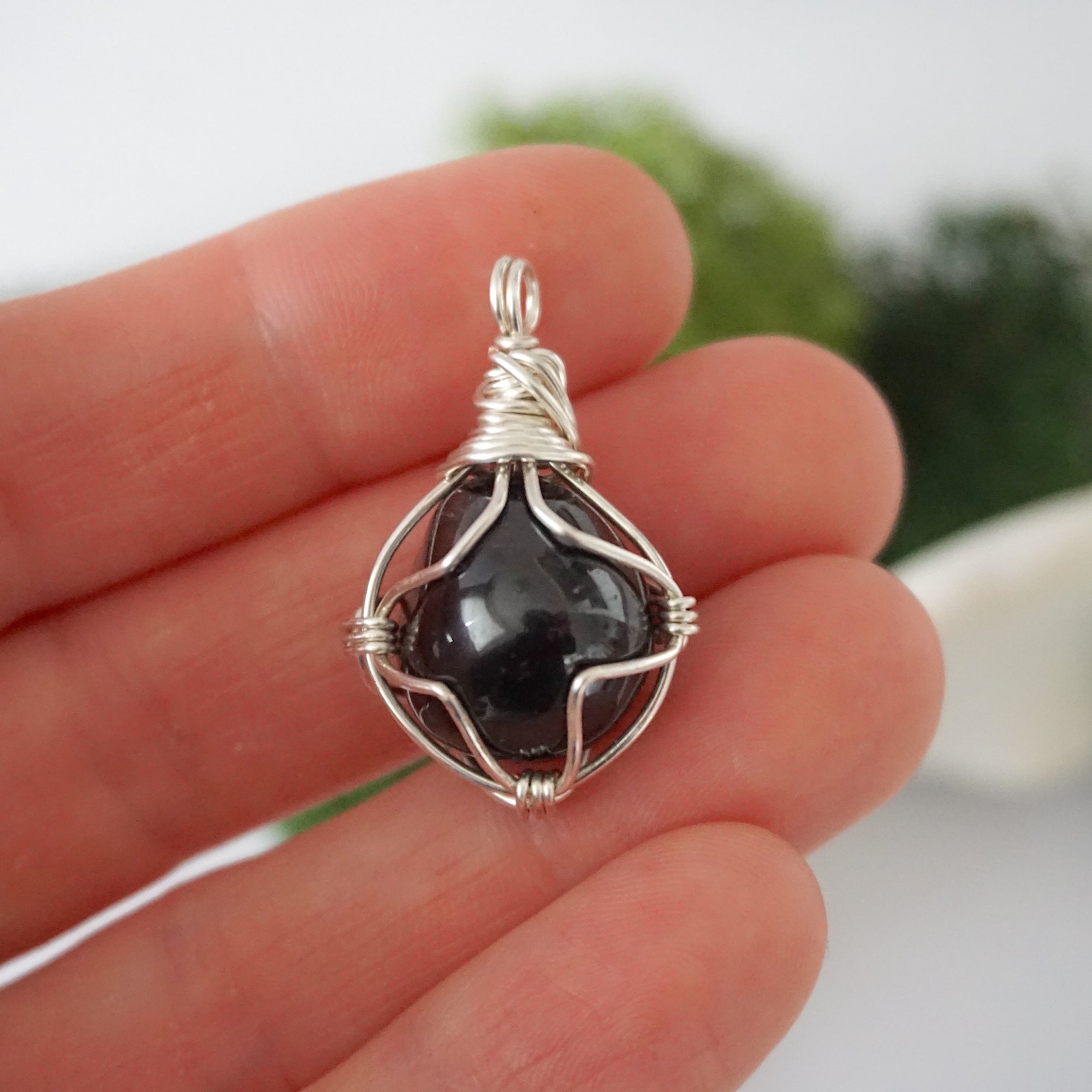 Simple raw garnet pendant shown in hand for size reference