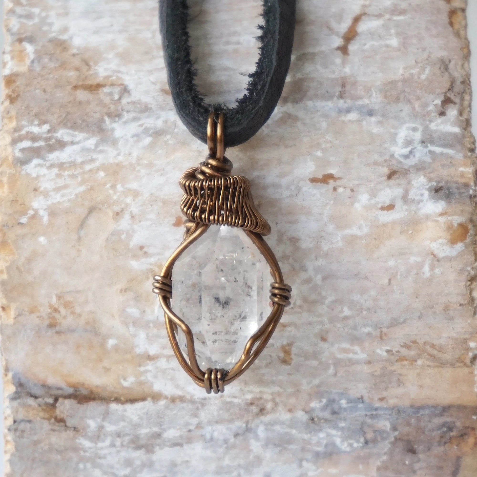 Detailed view of raw Herkimer diamond necklace for men with artisan wire wrapping in antique bronze copper.
