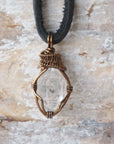 Detailed view of raw Herkimer diamond necklace for men with artisan wire wrapping in antique bronze copper.