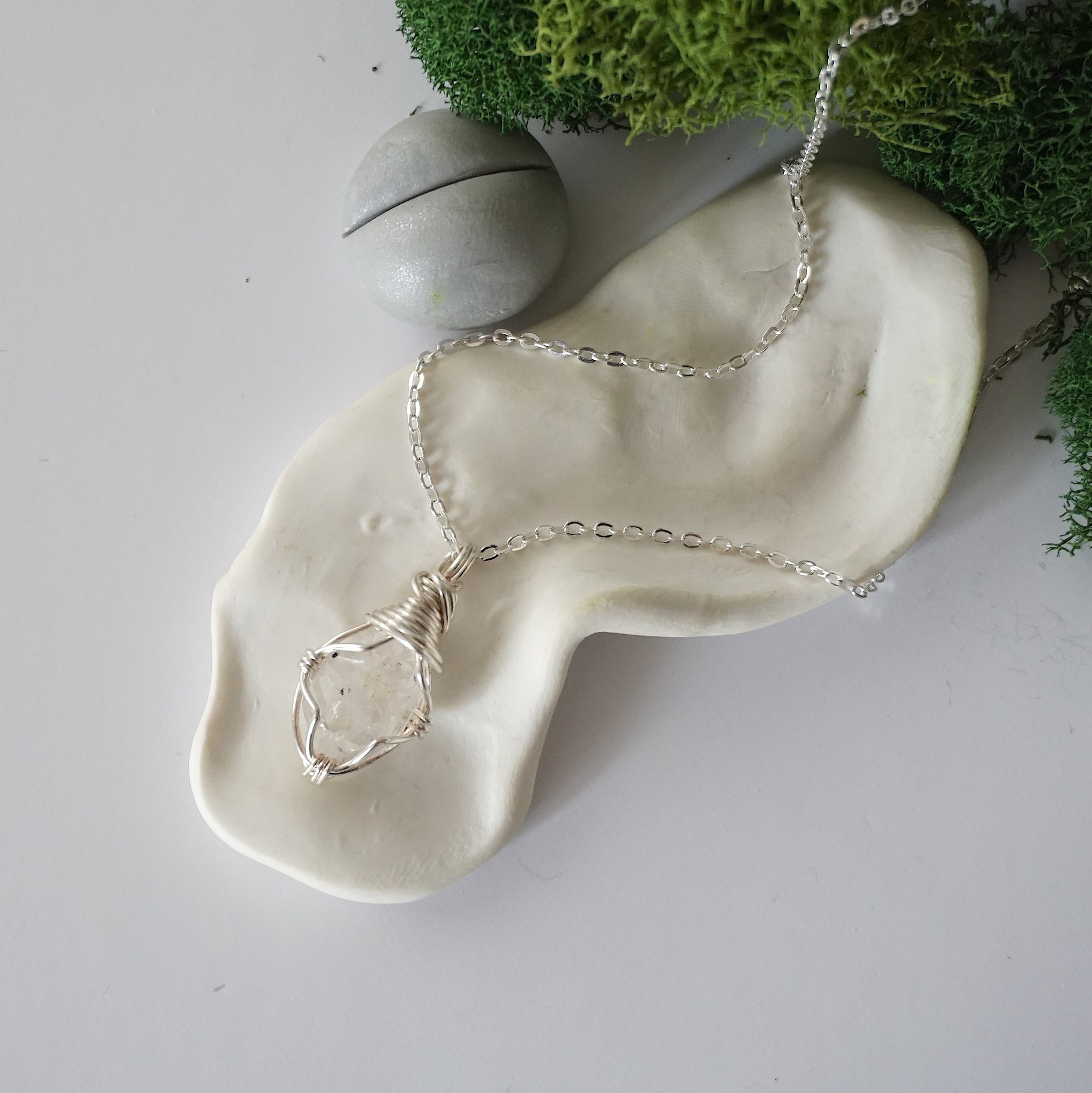 Simple raw Herkimer diamond necklace with silver plated brass chain laying flat