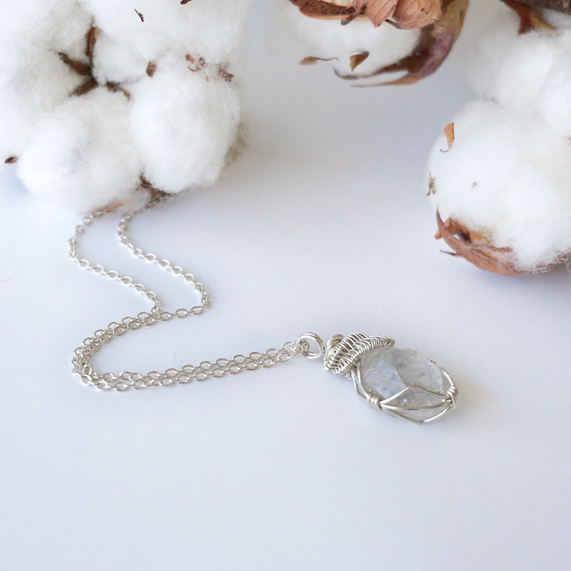 Detailed view of raw Herkimer diamond pendant on 925 sterling silver chain for women with handmade artisan wrapping.