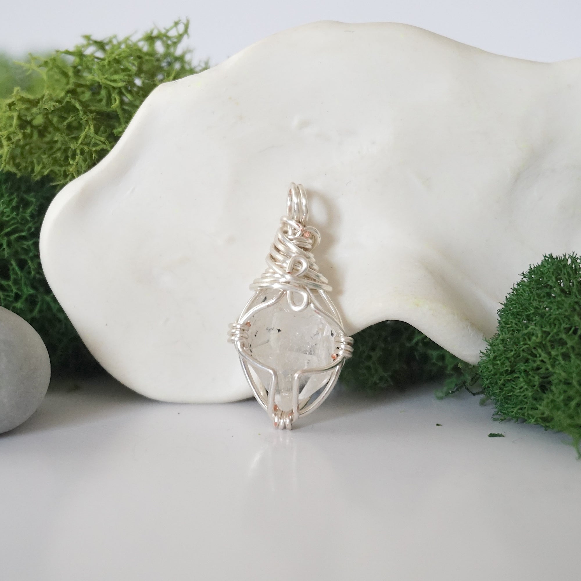 Back angle look at simple raw Herkimer diamond pendant with silver wire wrapping