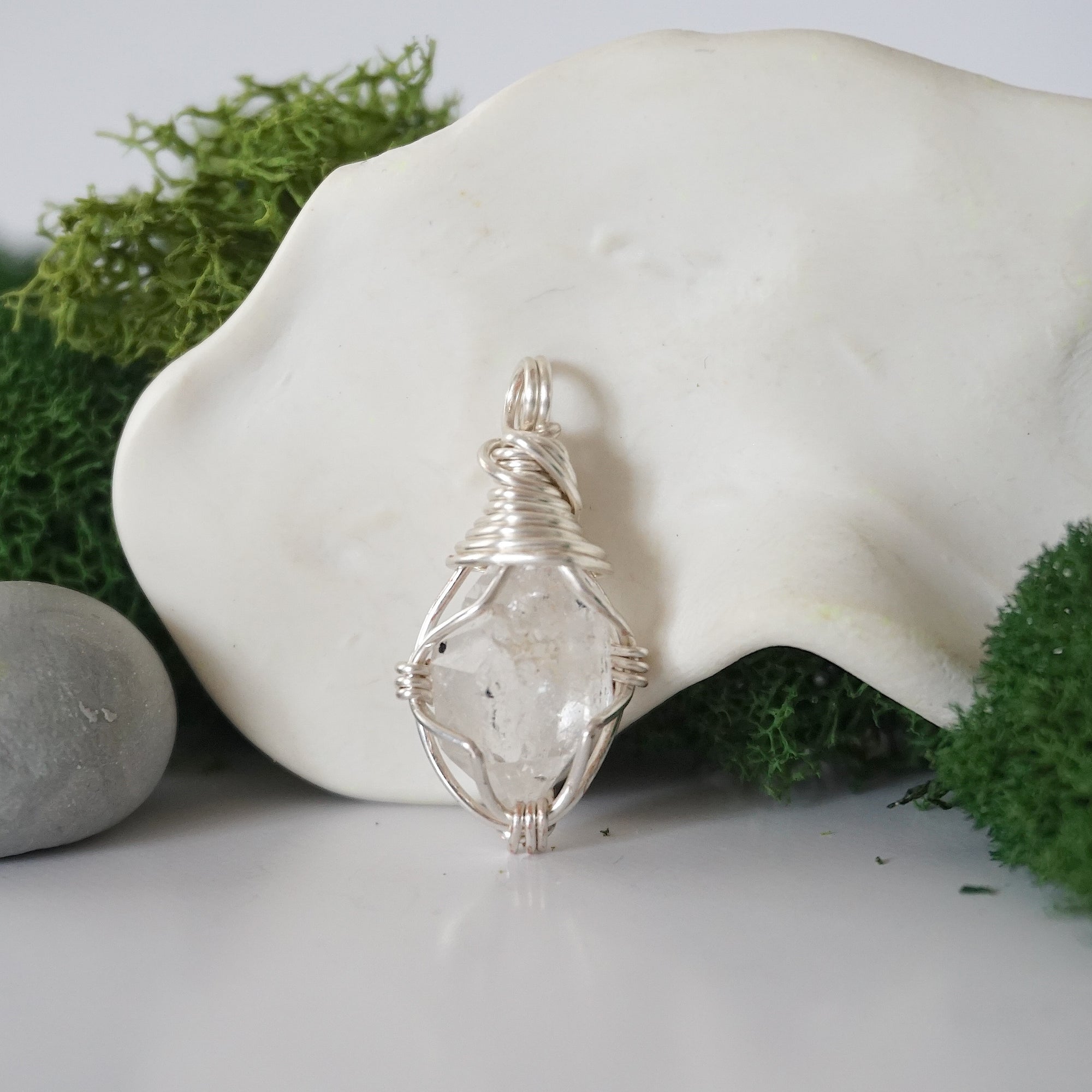 Detailed front angle view of simple raw Herkimer diamond pendant in silver wire