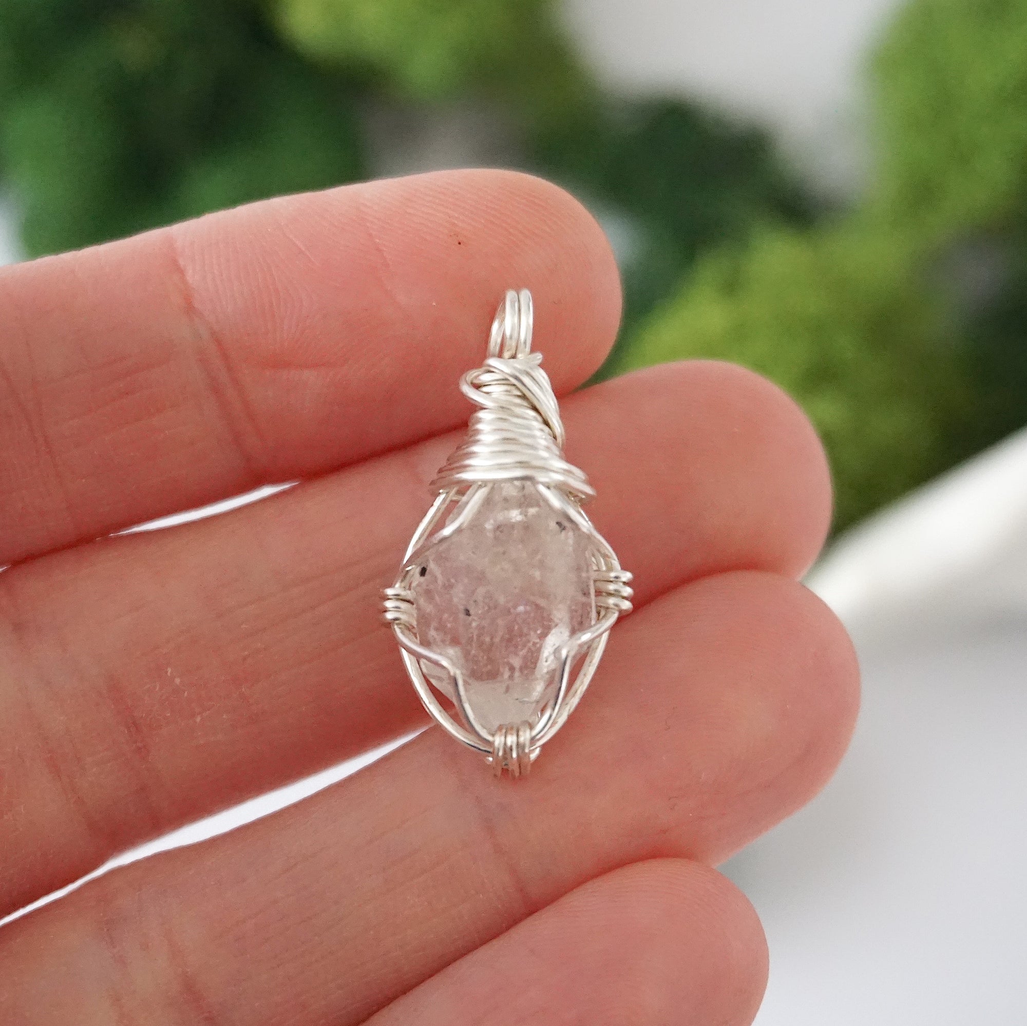 Simple raw Herkimer diamond pendant shown in hand for size reference