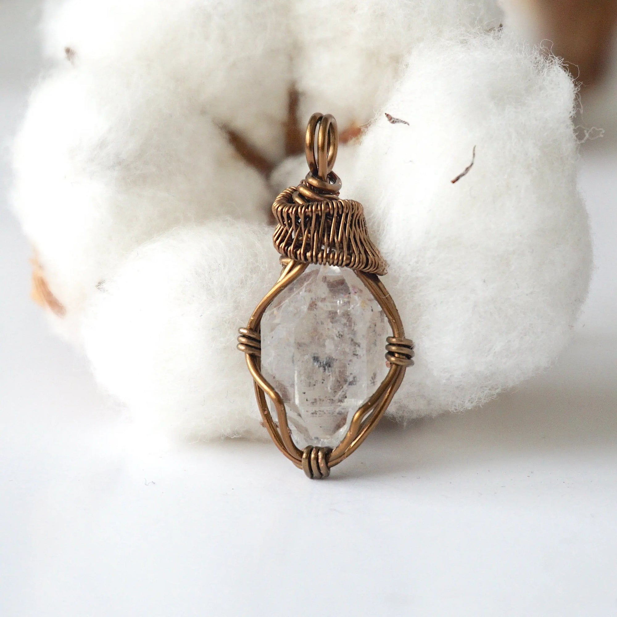 Front view of raw Herkimer diamond pendant for women with detailed artisan wire wrapping in antique bronze copper.