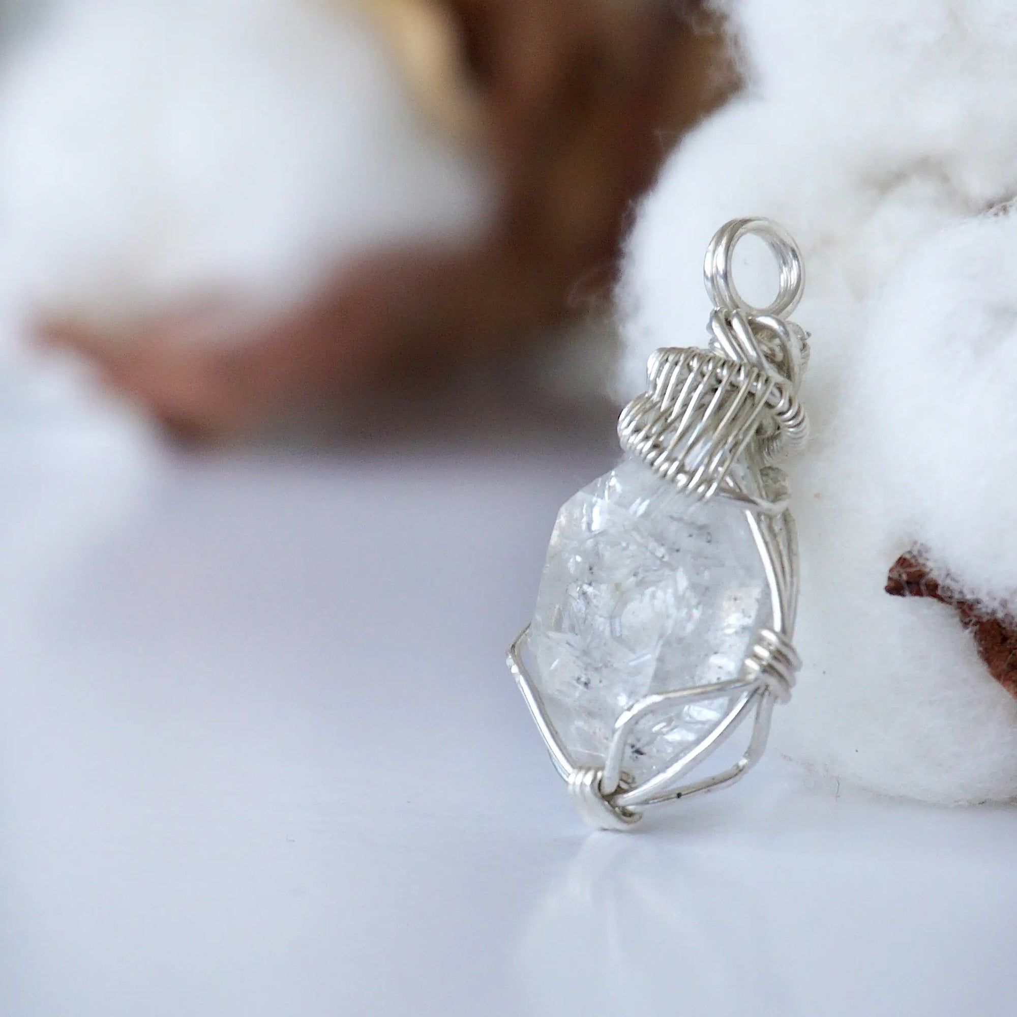 Left angle view of raw Herkimer diamond necklace for women highlighting artisan wire wrapping in 925 sterling silver.