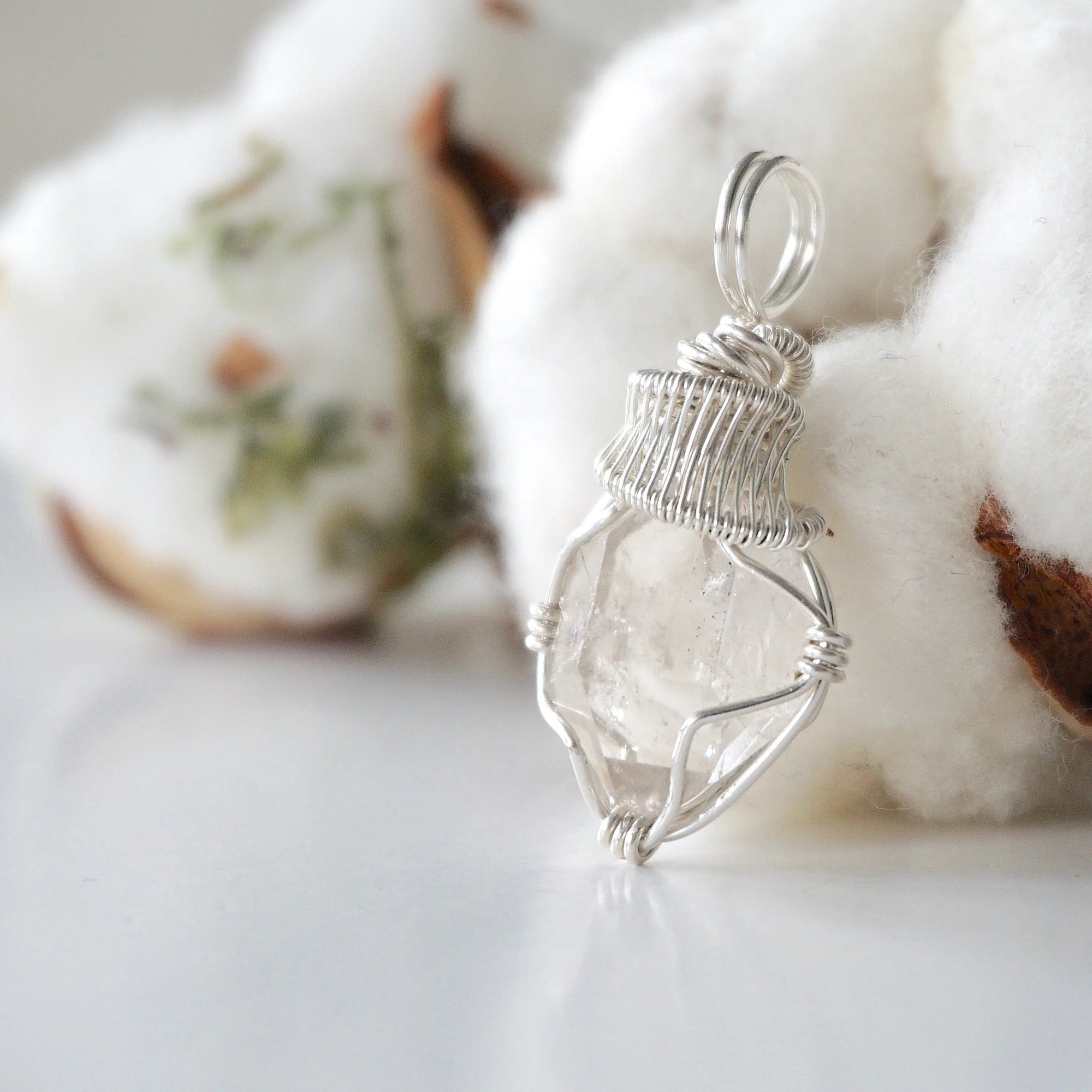 Left angle view of raw Herkimer diamond necklace for women highlighting artisan wire wrapping in 925 sterling silver.