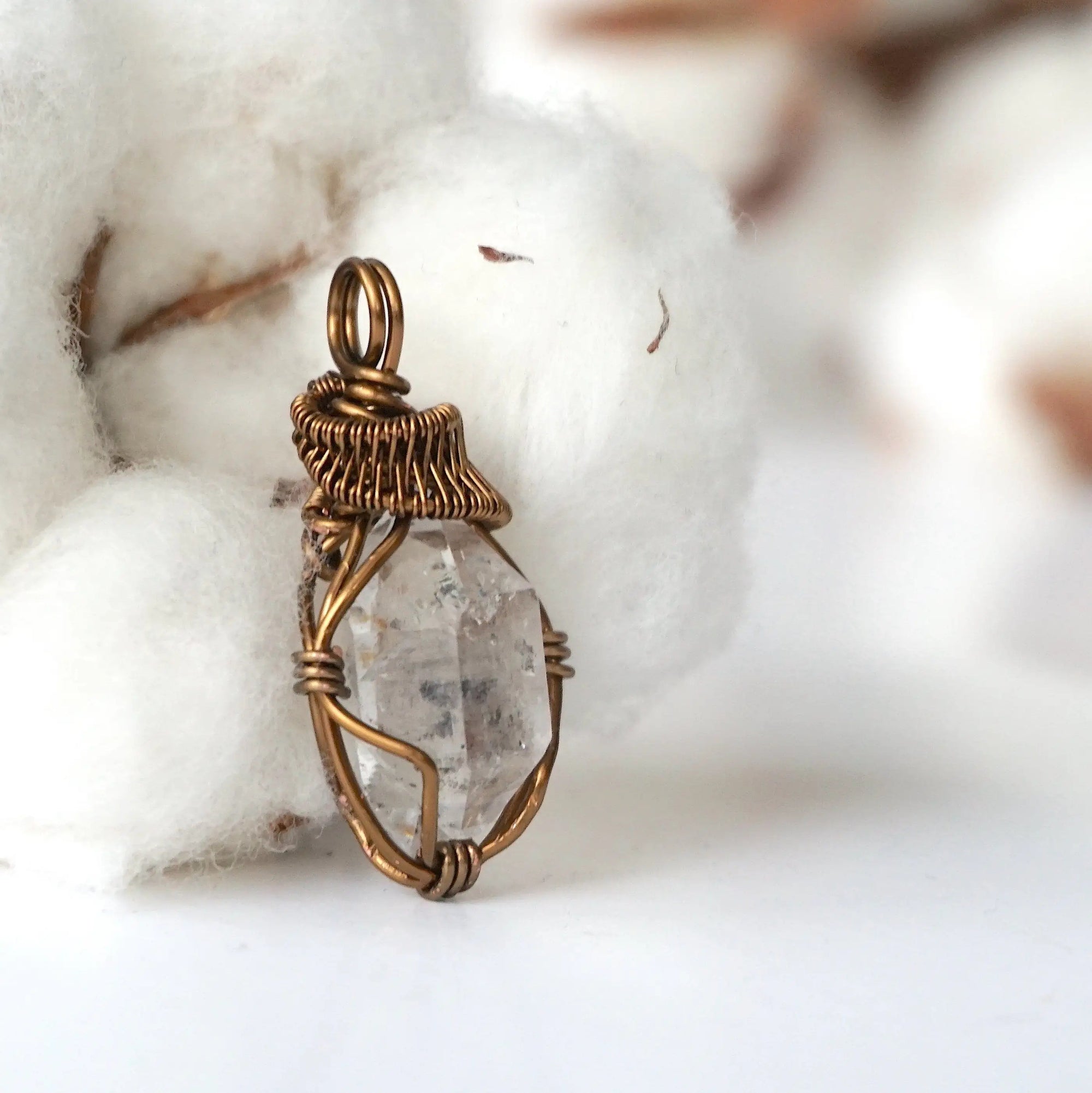 Right angle view of handmade Herkimer diamond pendant for women showing antique bronze copper wire artistry.