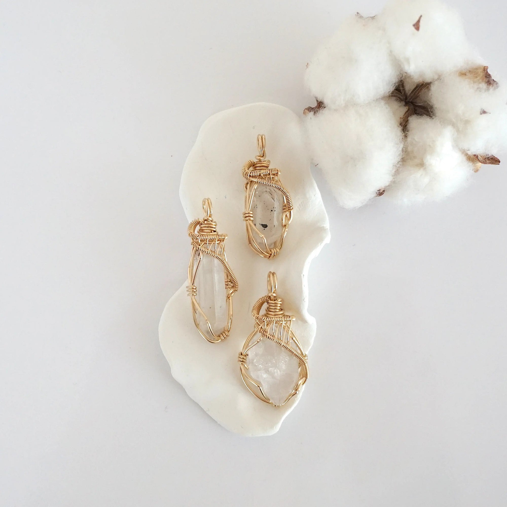 Three raw Herkimer diamond pendants in 14k gold filled, showing natural variation in size, shape, and clarity. Handcrafted April birthstone jewelry by Designs by Nature Gems.