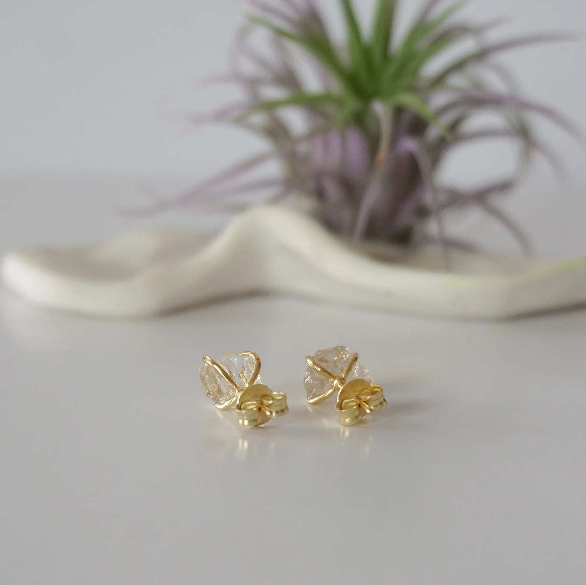 Back side angle view of raw Herkimer diamond stud earrings with minimalist prong setting in 14k gold vermeil.
