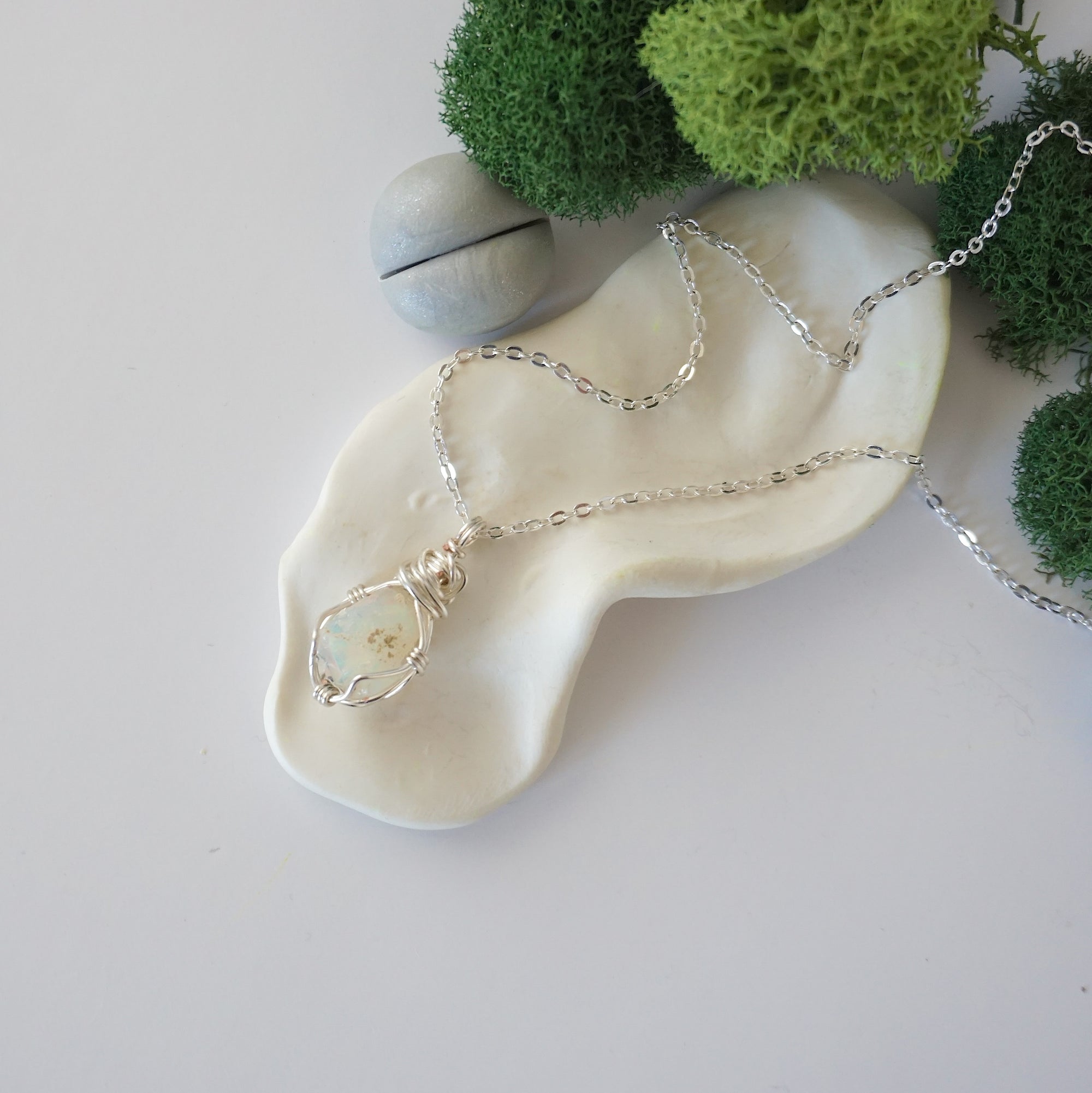 Simple raw opal necklace with silver plated brass chain laying flat
