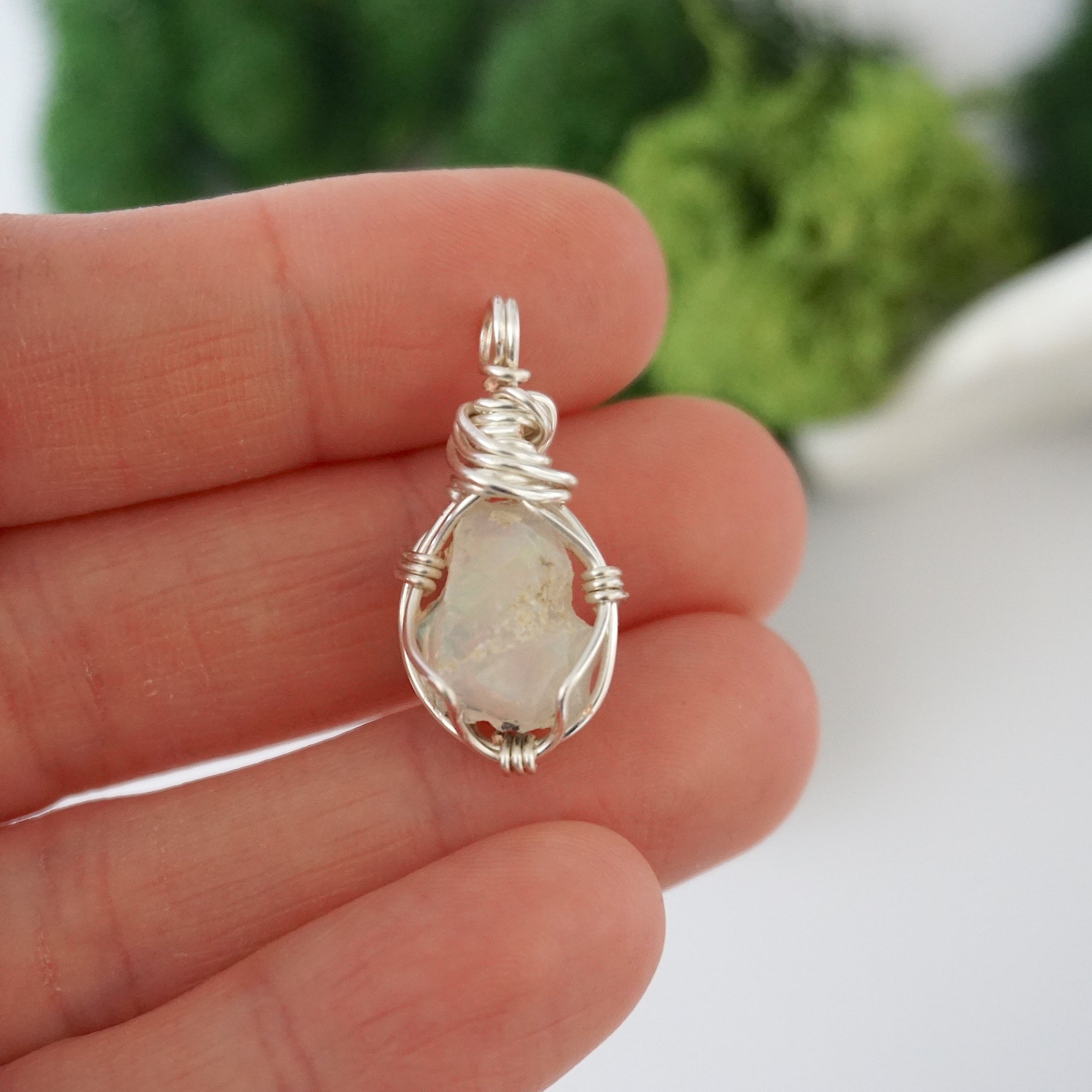 Simple raw opal pendant shown in hand for size reference