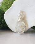Detailed side angle view of simple raw opal pendant in silver wire