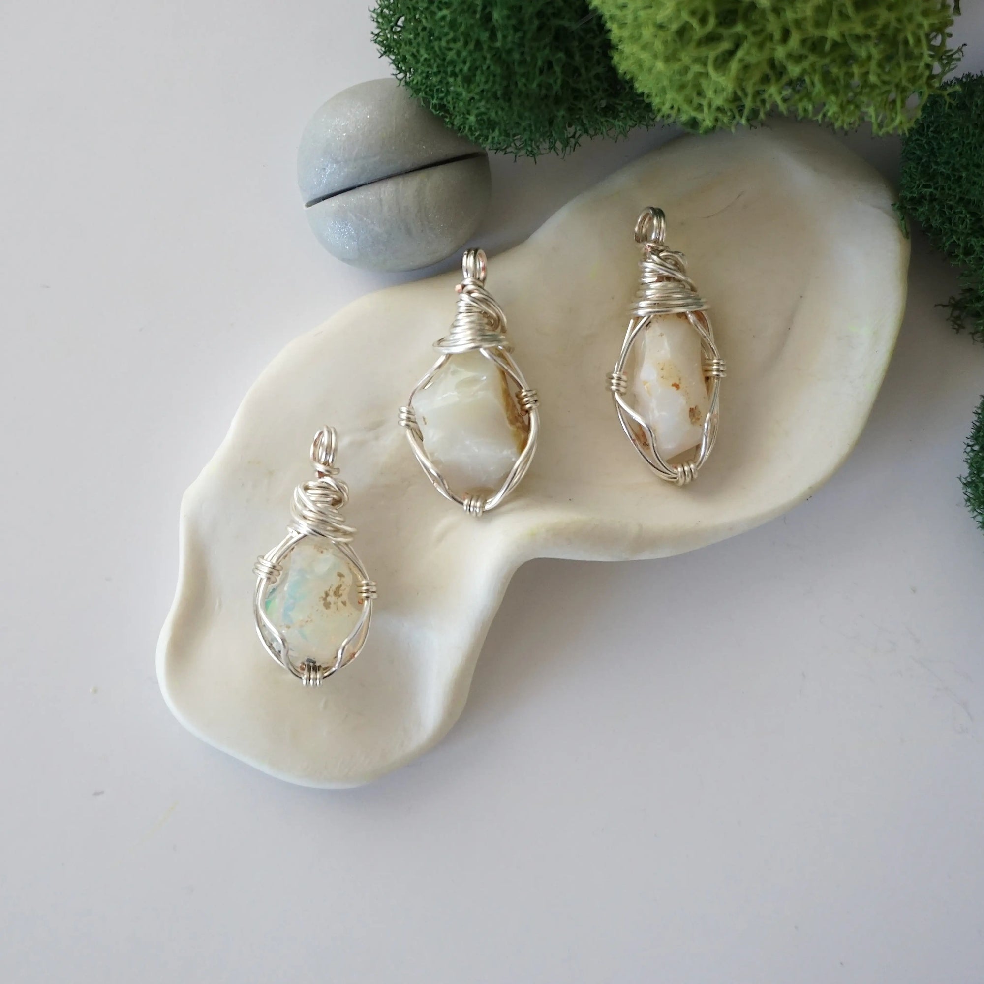 Three different raw opal pendants displayed for variation reference