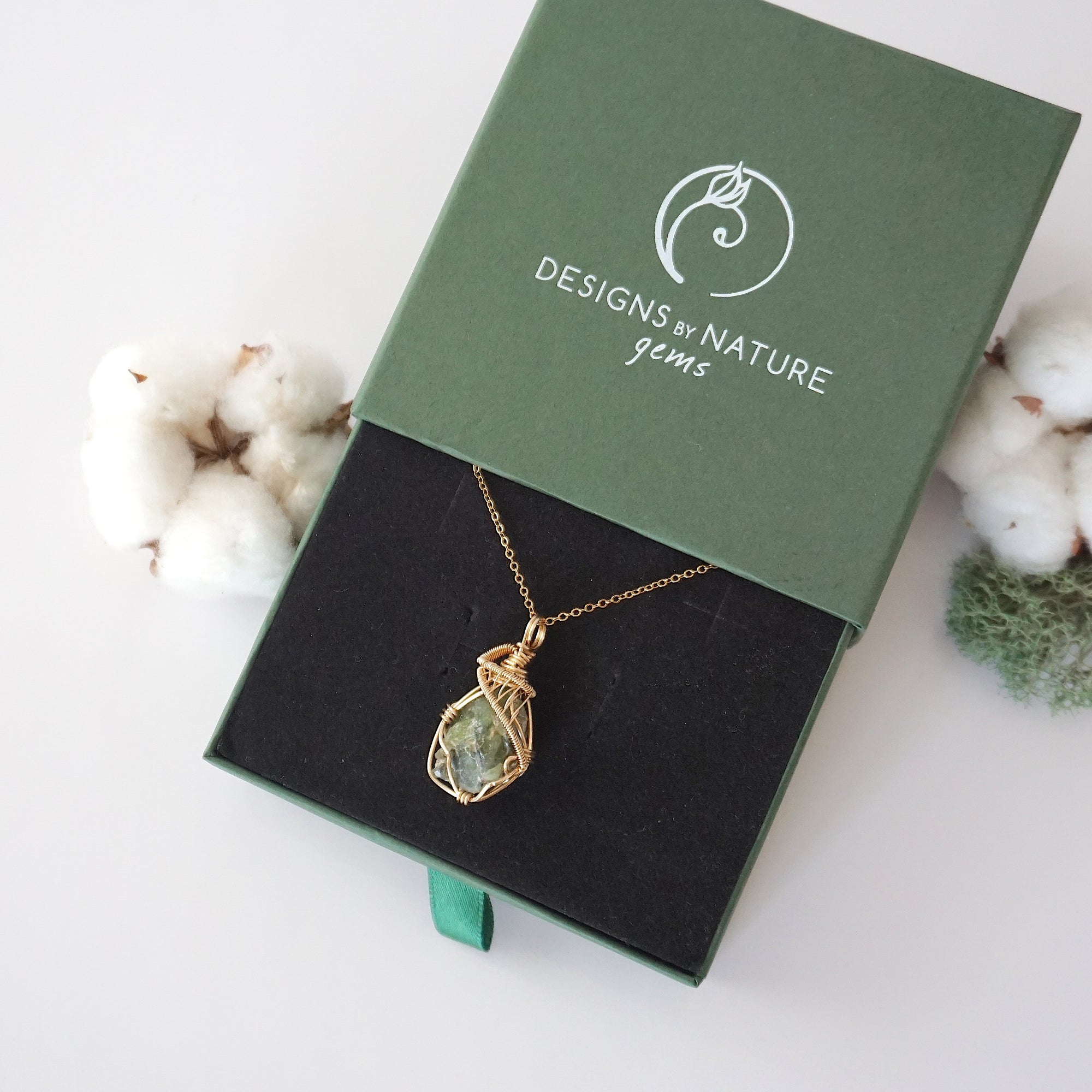 Raw peridot necklace in 14k gold filled displayed in branded Designs by Nature Gems jewelry box. Artisan August birthstone gift for women.