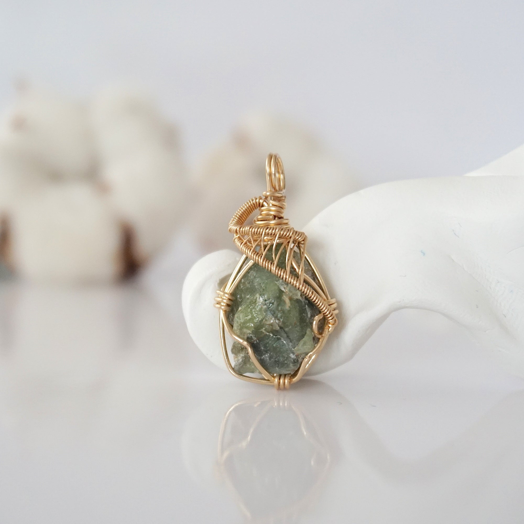 Detailed front view of raw peridot pendant in 14k gold filled. Unique wire wrapped August birthstone jewelry by Designs by Nature Gems.