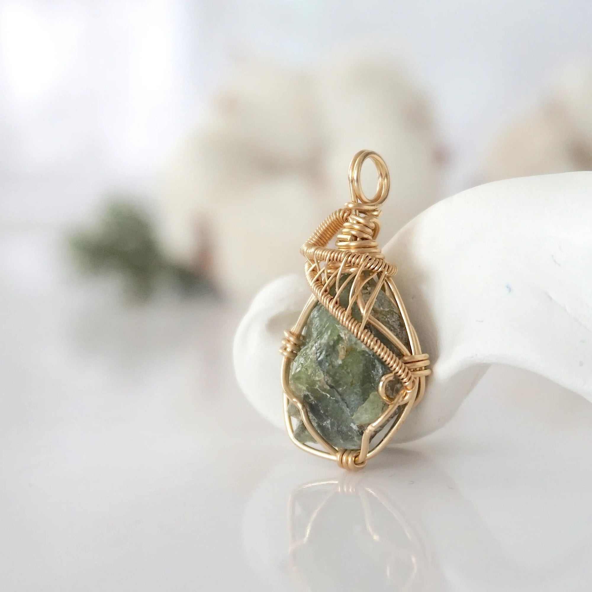 Side view of raw peridot pendant in 14k gold filled, showing artisan wire wrapping. Handcrafted August birthstone necklace by Designs by Nature Gems.