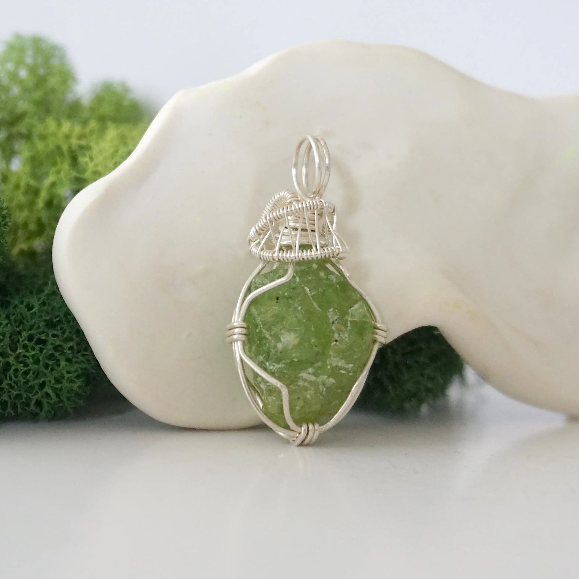 Right side detail of raw peridot crystal pendant — intricate 925 sterling silver wire weaving technique, handcrafted artisan wire wrapped jewelry, Designs by Nature Gems