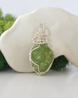Right side detail of raw peridot crystal pendant — intricate 925 sterling silver wire weaving technique, handcrafted artisan wire wrapped jewelry, Designs by Nature Gems