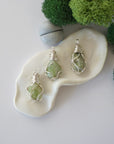 Three different raw peridot pendants displayed for variation reference