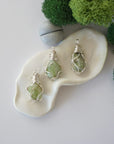 Three different raw peridot pendants displayed for variation reference