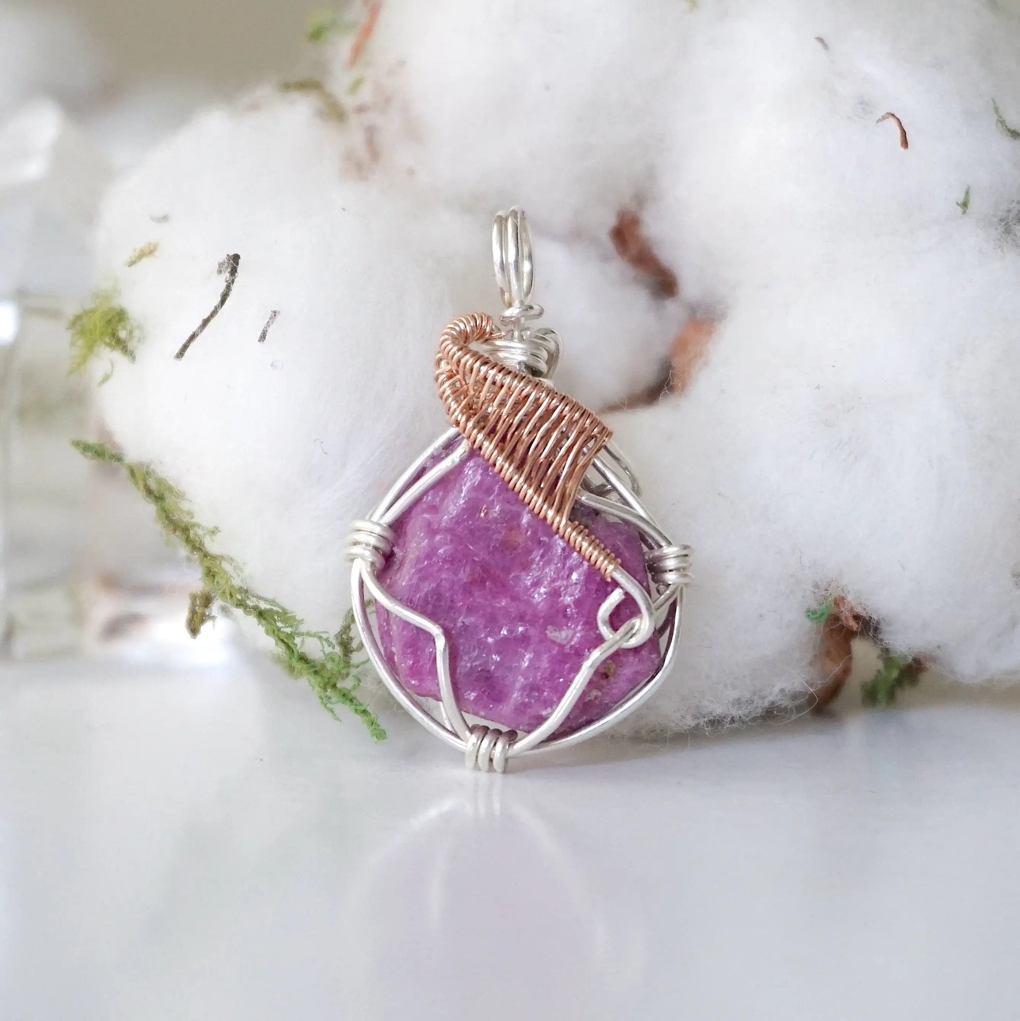 Detailed front view of raw pink ruby pendant in sterling silver and 14k rose gold filled. Unique wire wrapped July birthstone jewelry by Designs by Nature Gems.