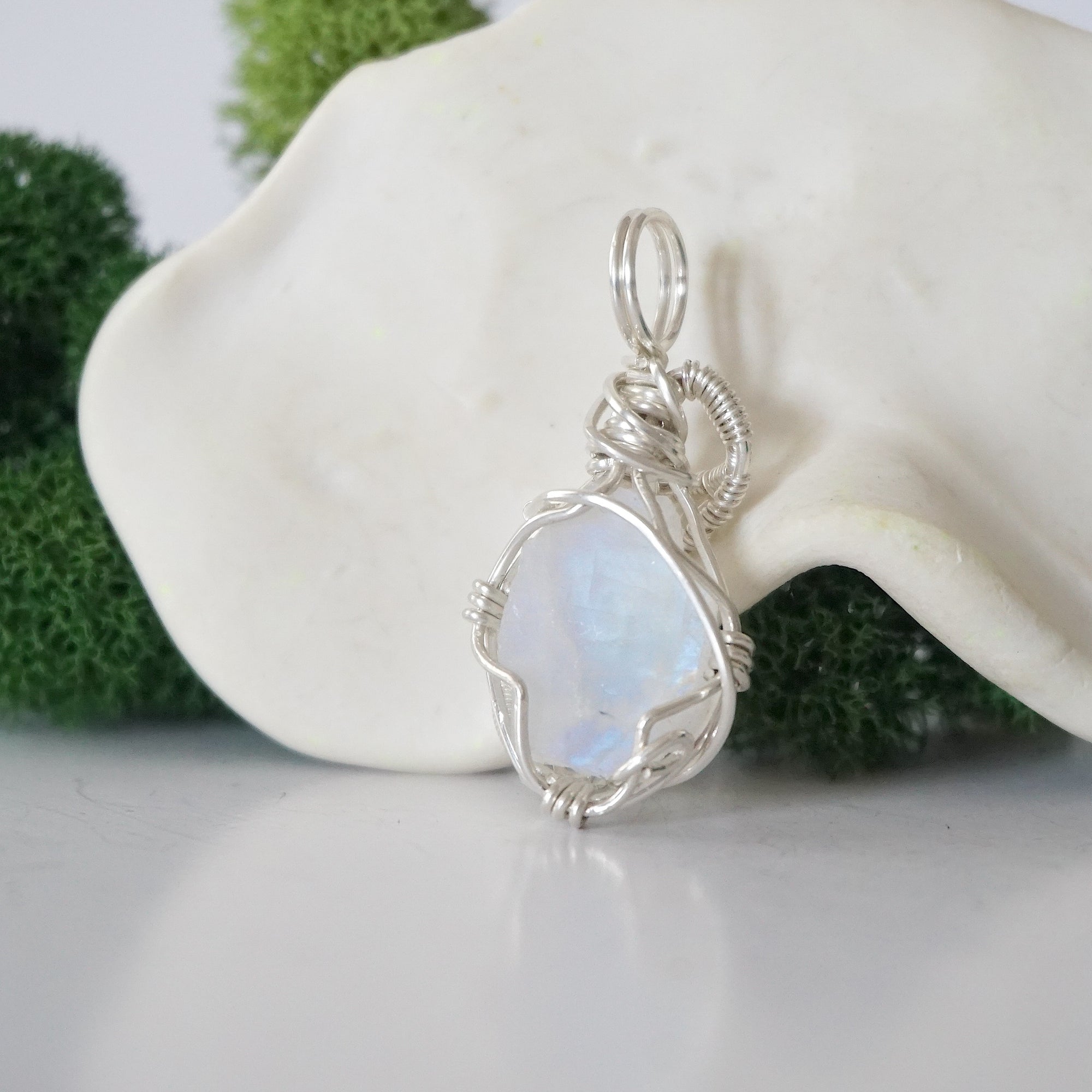 Back view of raw rainbow moonstone necklace pendant with handcrafted sterling silver wire work