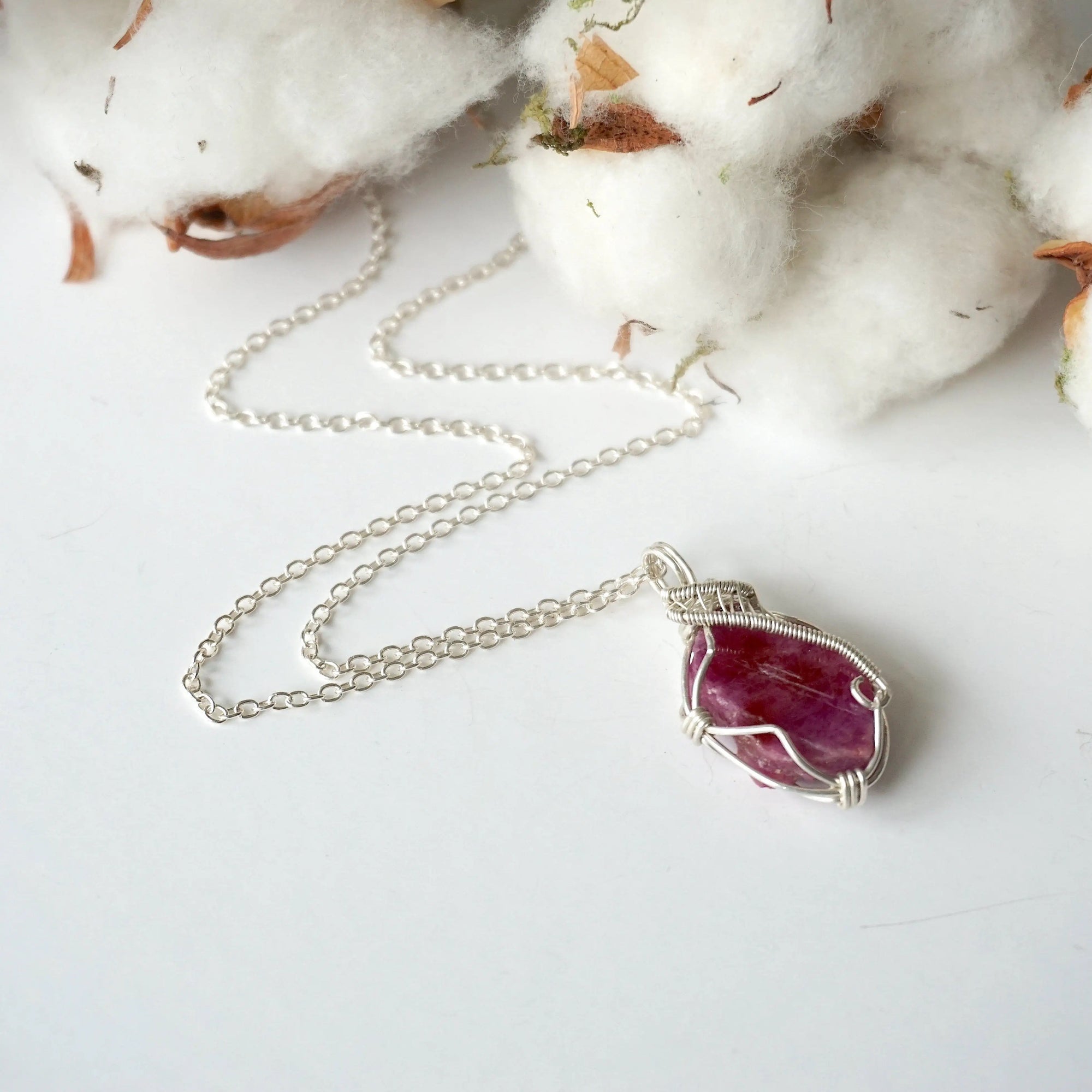 Raw ruby necklace for women on sterling silver chain, laying flat, natural pink ruby pendant, artisan wire wrapped