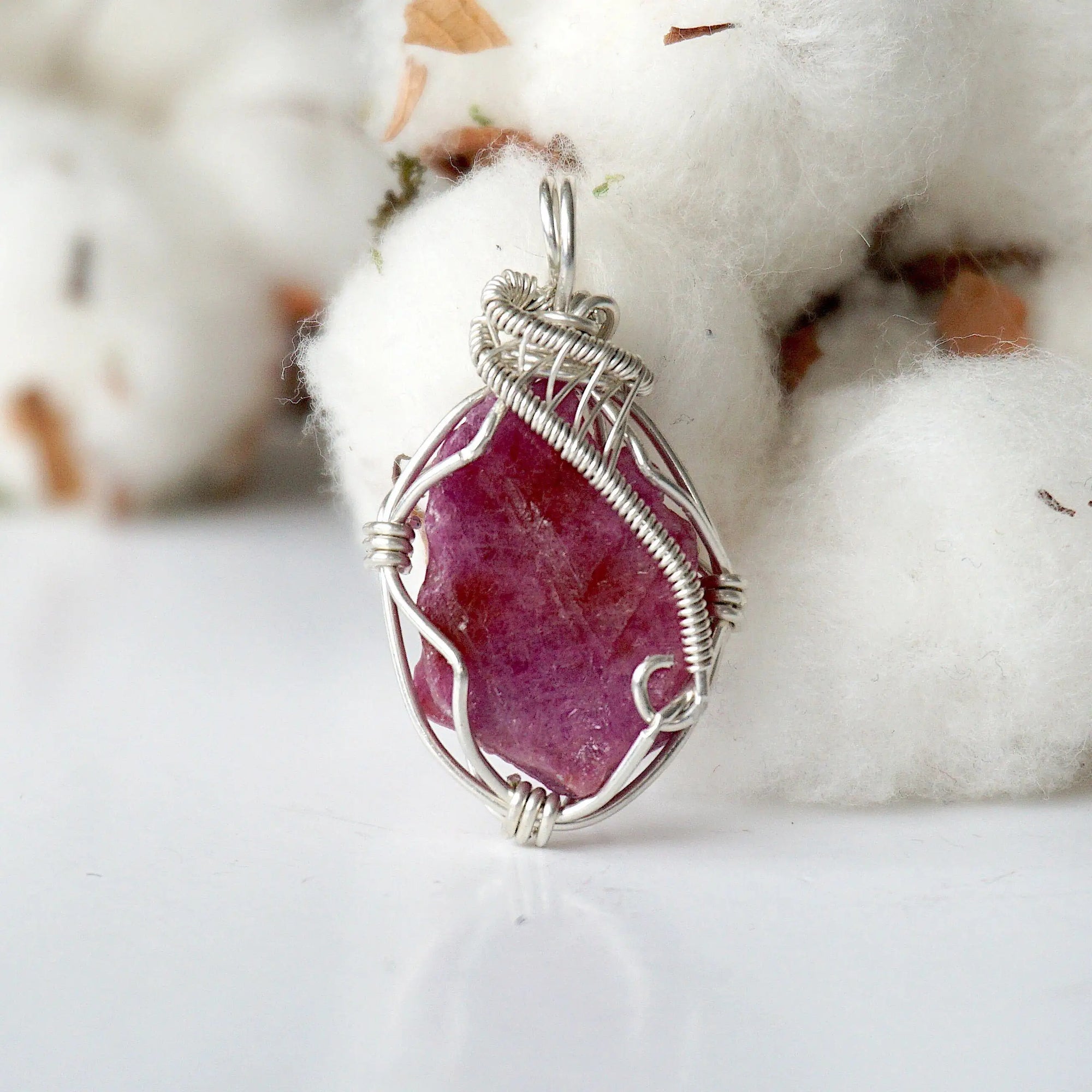 Detailed front side look at raw ruby pendant, natural pink ruby, sterling silver artisan wire wrapping