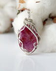 Detailed front side look at raw ruby pendant, natural pink ruby, sterling silver artisan wire wrapping