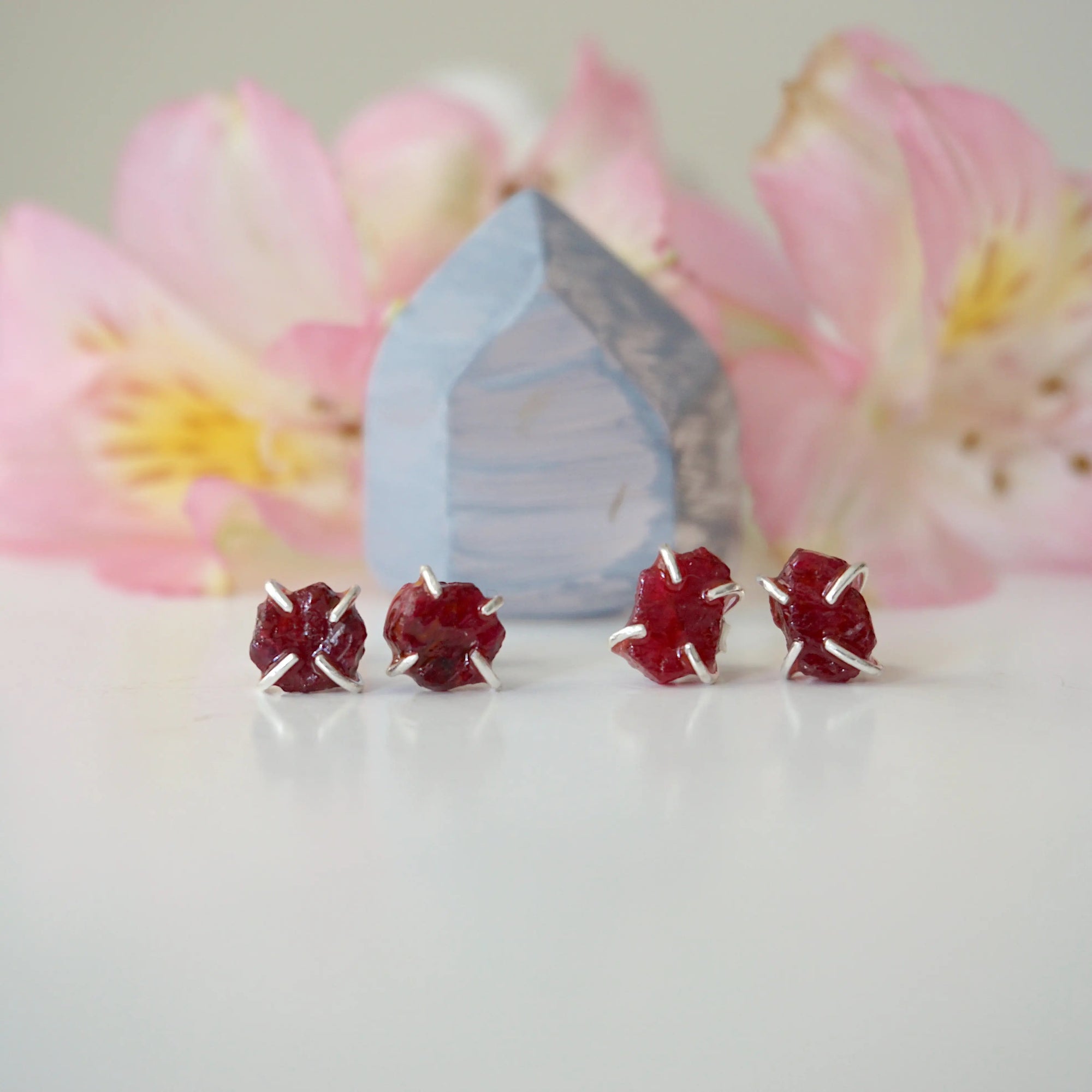 Two pairs of raw ruby prong stud earrings showing natural variation in stone shape, size, and colour — select your own pair, one of a kind by nature