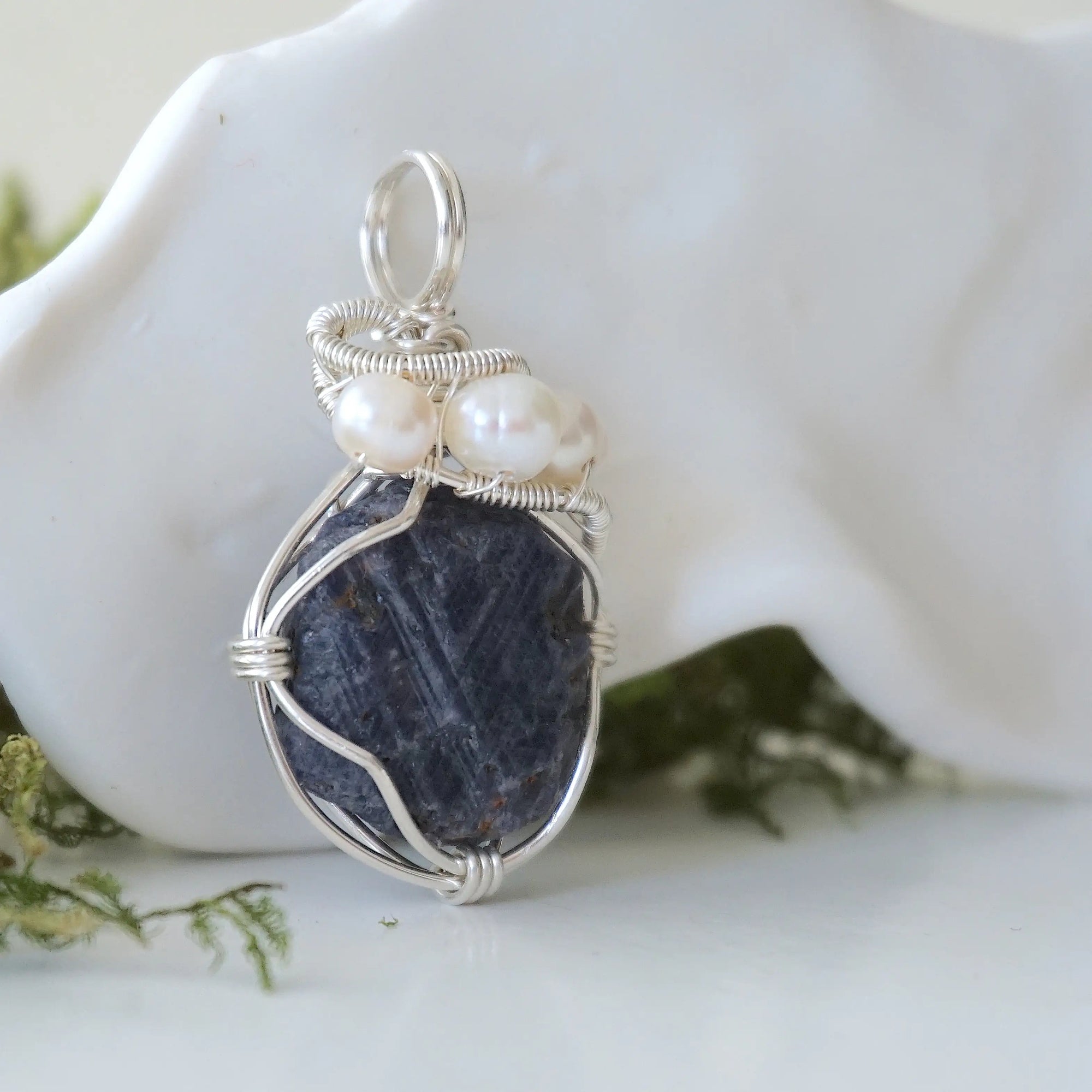 Right-angle detail of raw sapphire and freshwater pearl pendant showing artisan sterling silver wire-wrapping — handcrafted September and June birthstone necklace