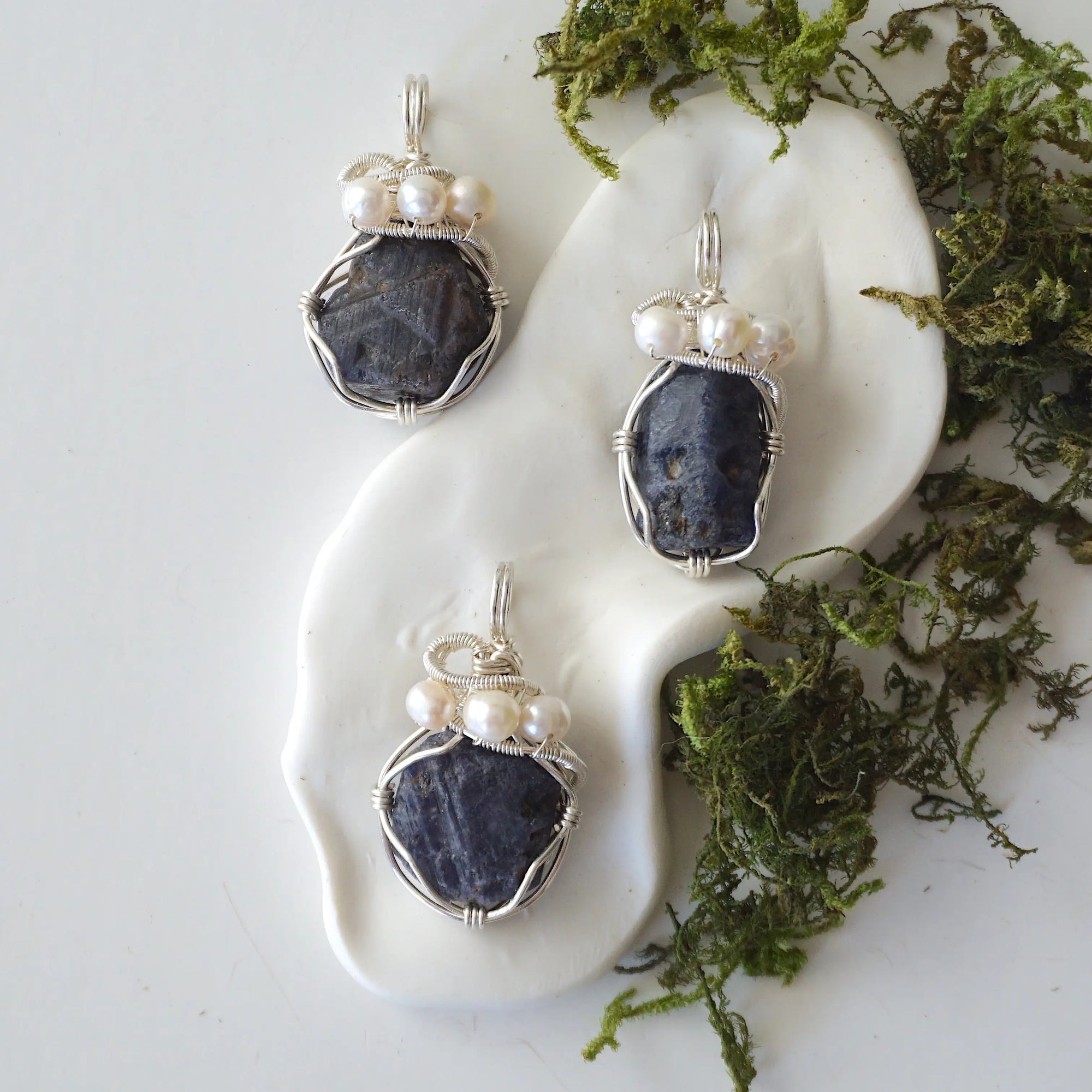 Three raw sapphire and pearl pendants showing natural variation in sapphire size, shape, and depth of colour — each sterling silver wire-wrapped necklace is individually handcrafted and one of a kind
