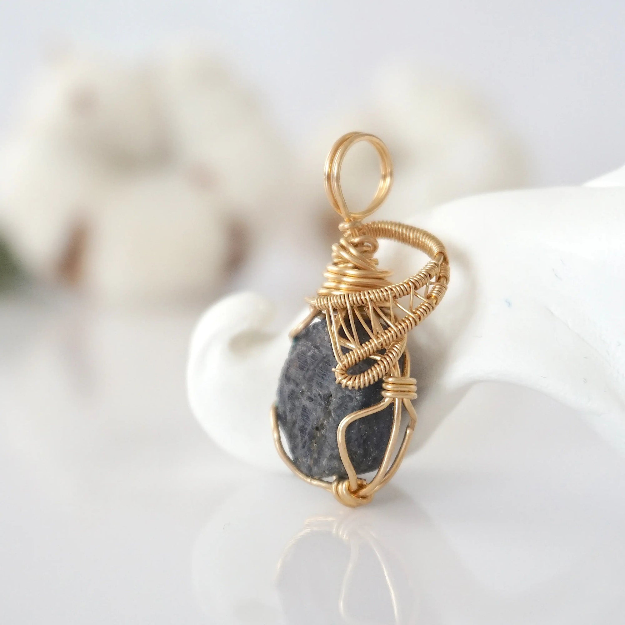 Side view of raw sapphire pendant in 14k gold filled, showing artisan wire wrapping. Handcrafted September birthstone necklace by Designs by Nature Gems.