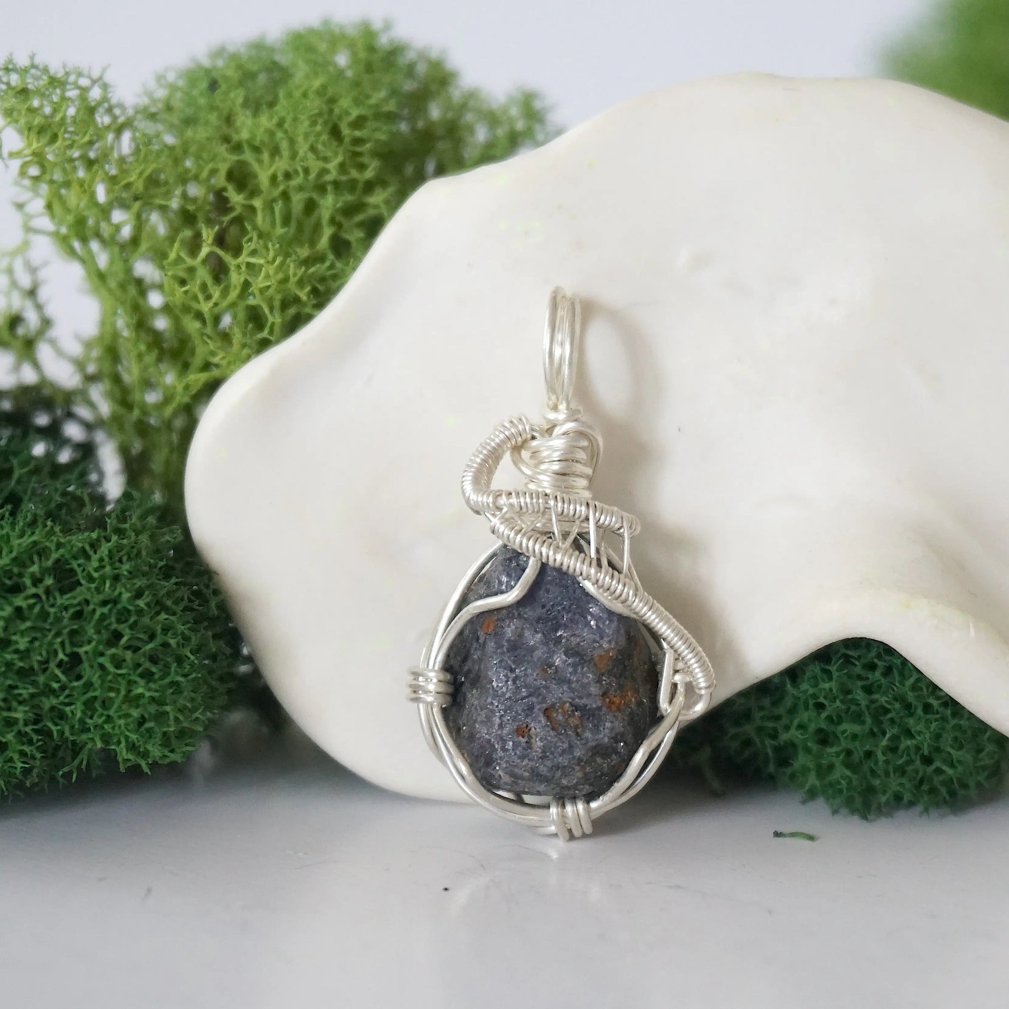 Front view of raw sapphire pendant — natural unpolished dark blue corundum stone hand-wrapped in detailed 925 sterling silver wire, handcrafted artisan jewelry