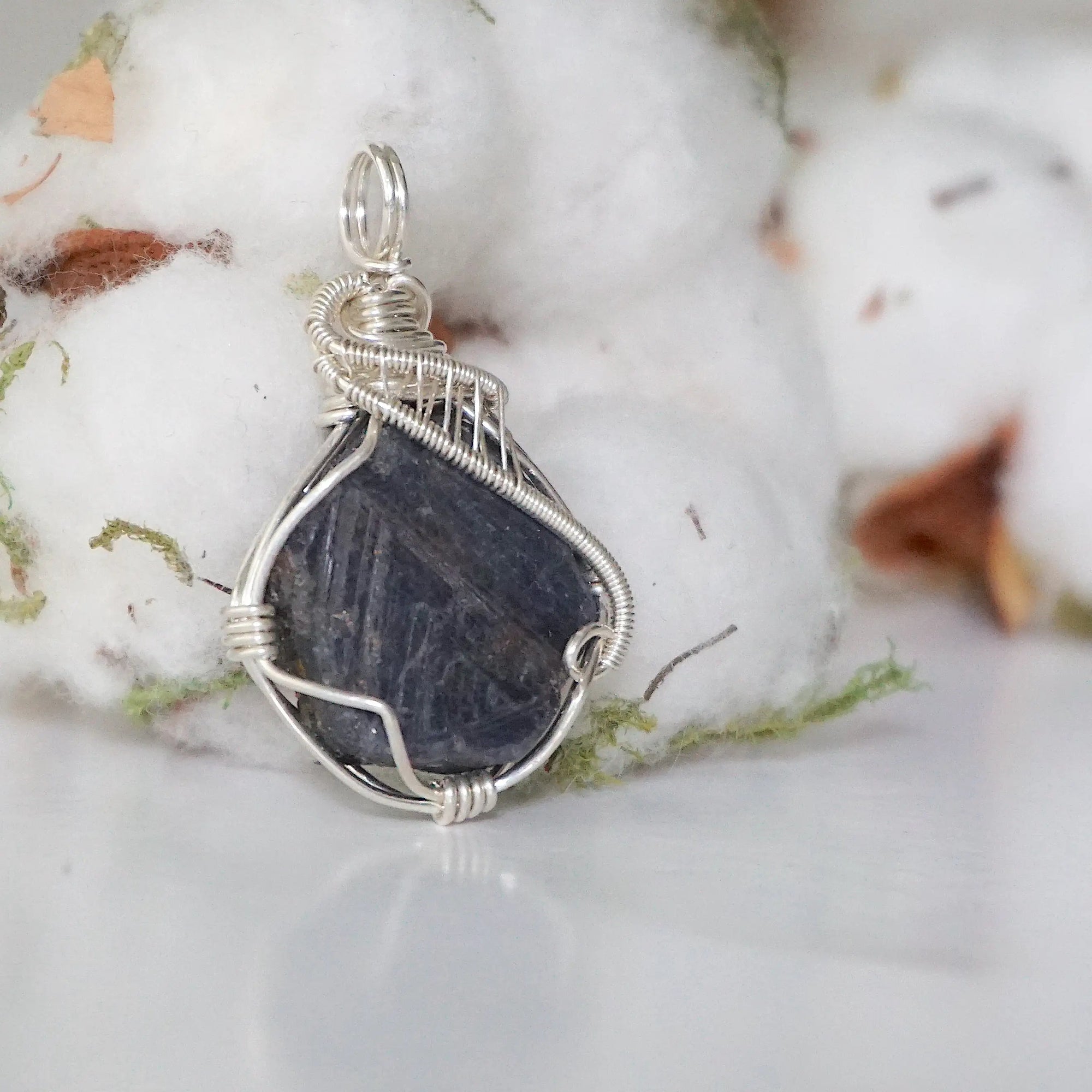 Right-angle detail of women's raw sapphire pendant showing artisan wire-wrapping in bright 925 sterling silver — handcrafted crystal necklace