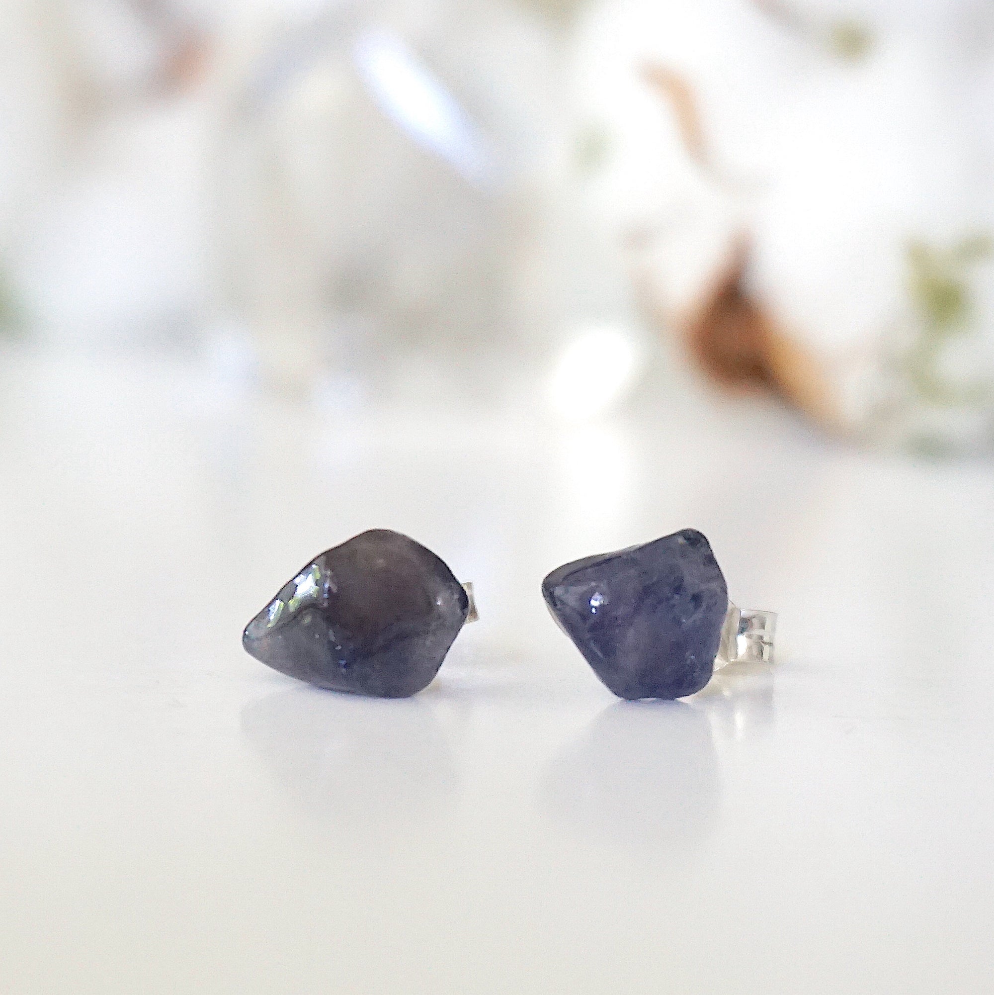 Front view of natural raw sapphire stud earrings showing their unique blue colour and minimalist 925 sterling silver setting