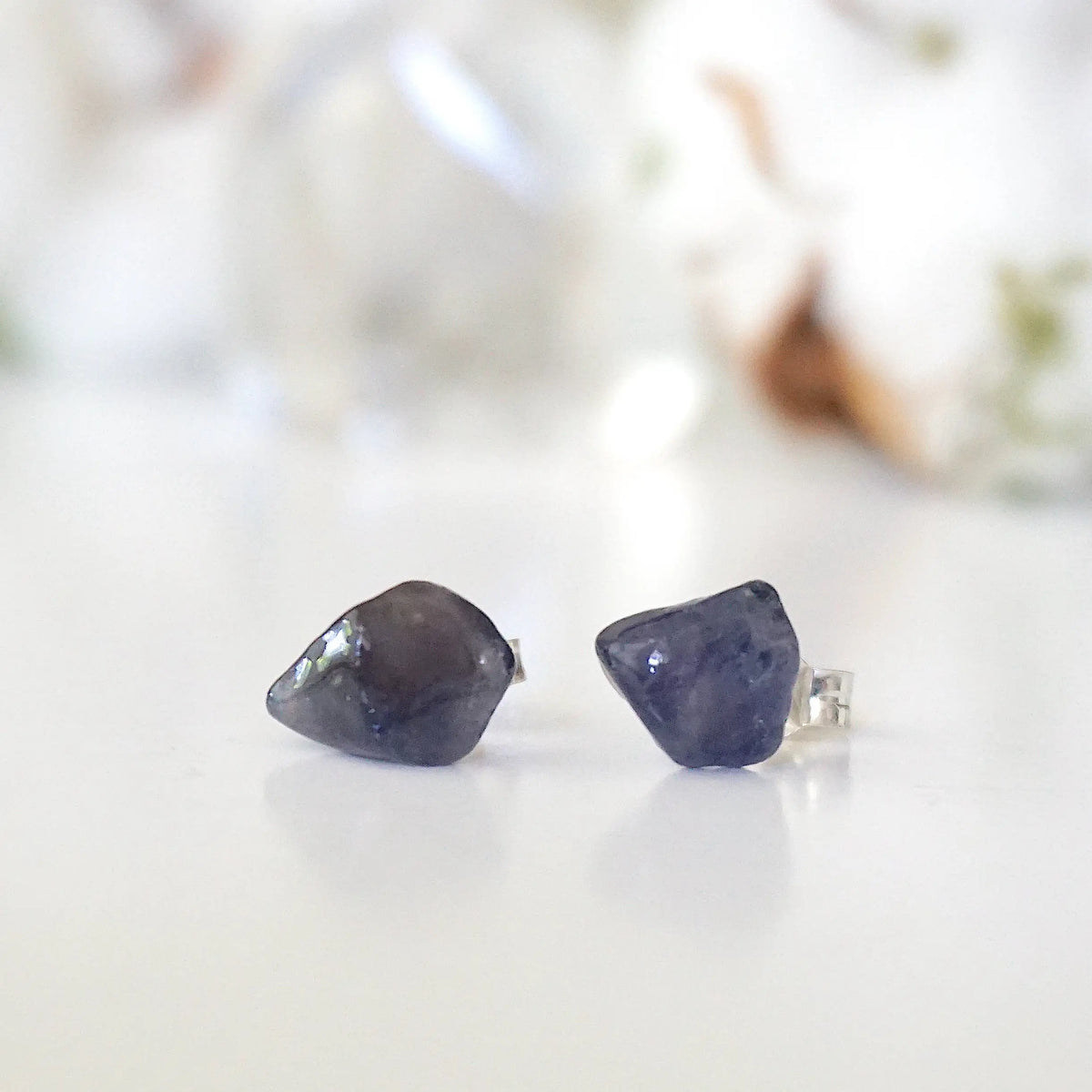 Front view of natural raw sapphire stud earrings showing their unique blue colour and minimalist 925 sterling silver setting