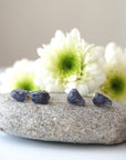 Two pairs of raw sapphire stud earrings showing natural variation in stone shape, size, and shade of blue — each pair is one of a kind