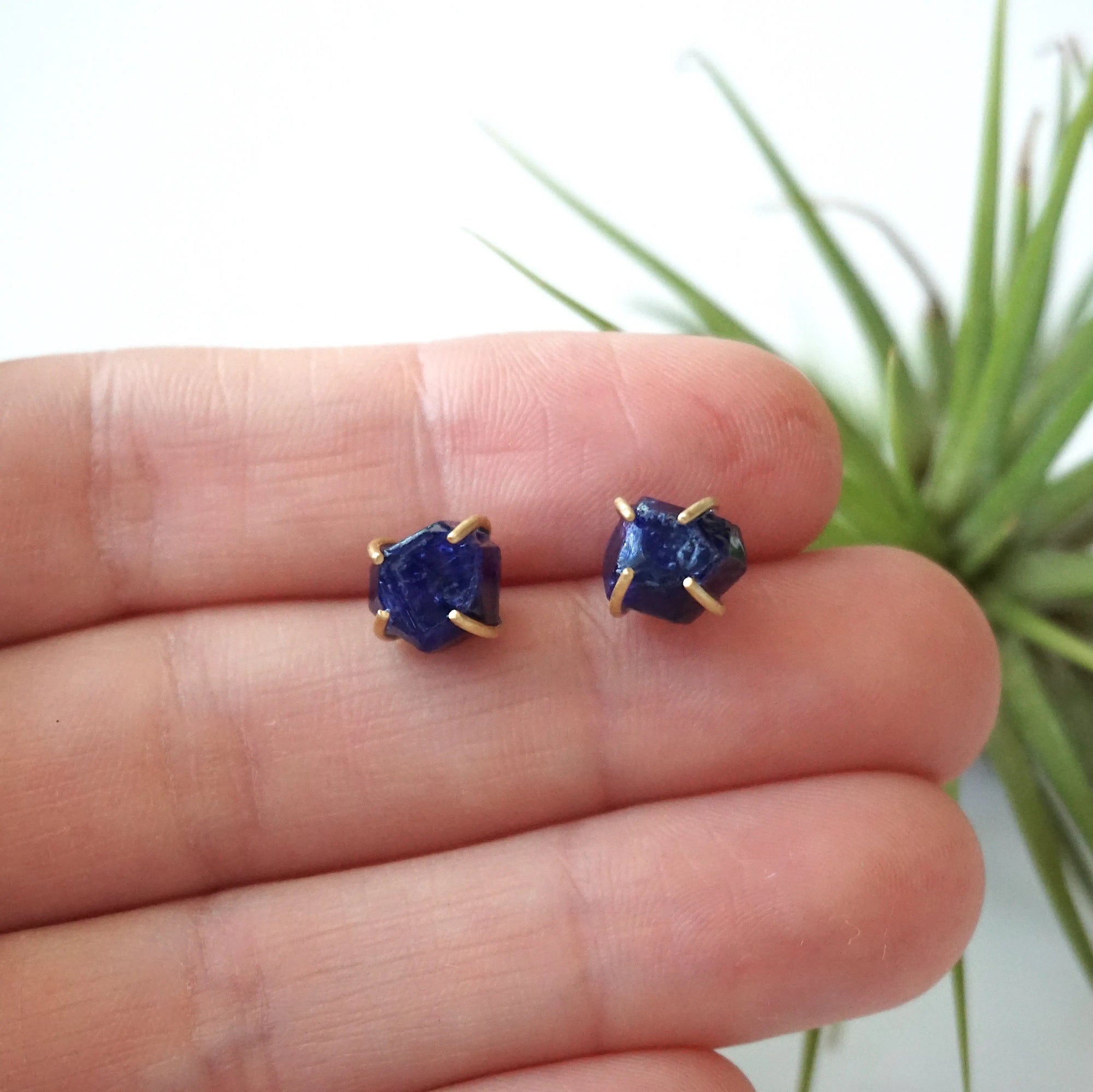 Raw sapphire stud earrings held in hand to show their natural 6–9mm size — 14k gold vermeil minimalist birthstone earrings