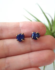 Raw sapphire stud earrings held in hand to show their natural 6–9mm size — 14k gold vermeil minimalist birthstone earrings
